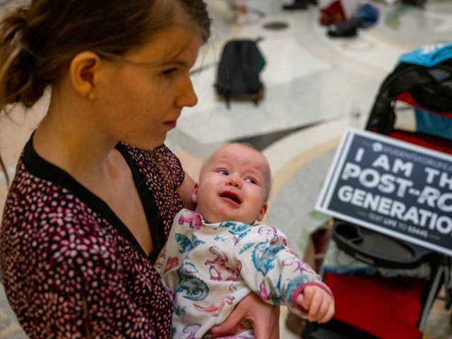 <p>An abortion rights protester holds her baby inside the Texas capitol building in March 2023, seven months after state legislators banned nearly all abortions. The number of abortions in Texas has plunged from several thousand per month to less than ten after Roe V Wade was overturned </p>