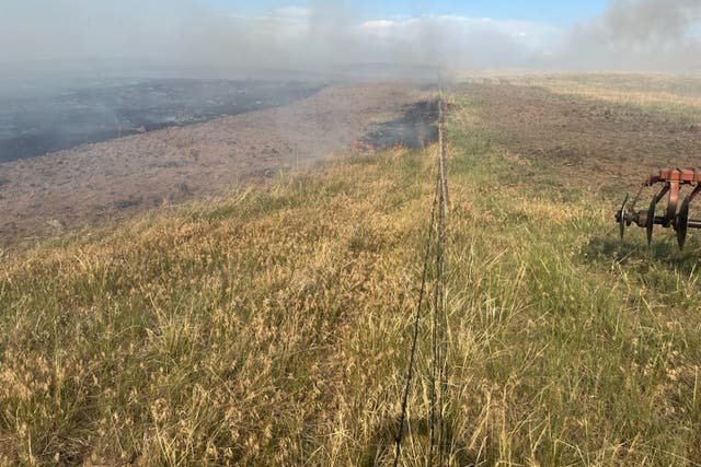 <p>A fire smolders across the prairie near Richard Holtorf’s ranch in Colorado</p>