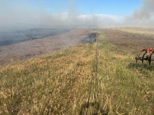 <p>A fire smolders across the prairie near Richard Holtorf’s ranch in Colorado</p>