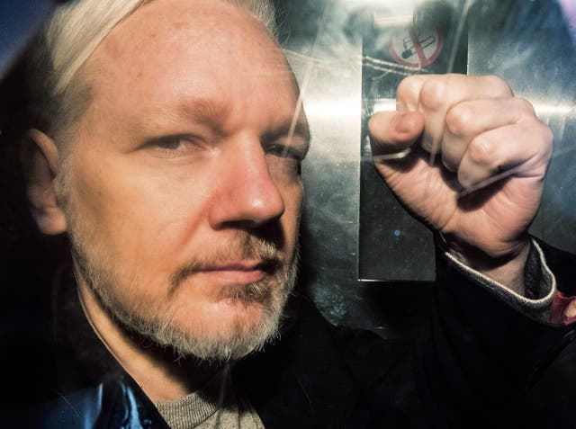 <p>WikiLeaks founder Julian Assange gestures from the window of a prison van as he is driven into Southwark Crown Court in London on May 1, 2019, before being sentenced to 50 weeks in prison for breaching his bail conditions in 2012</p>
