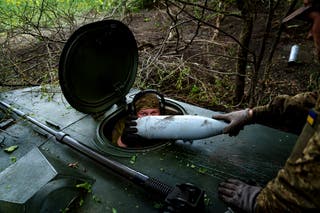 A Ukrainian soldier from the 57th Brigade loads an artillery shell to fire on Russian positions at the front line in the Kharkiv region of Ukraine