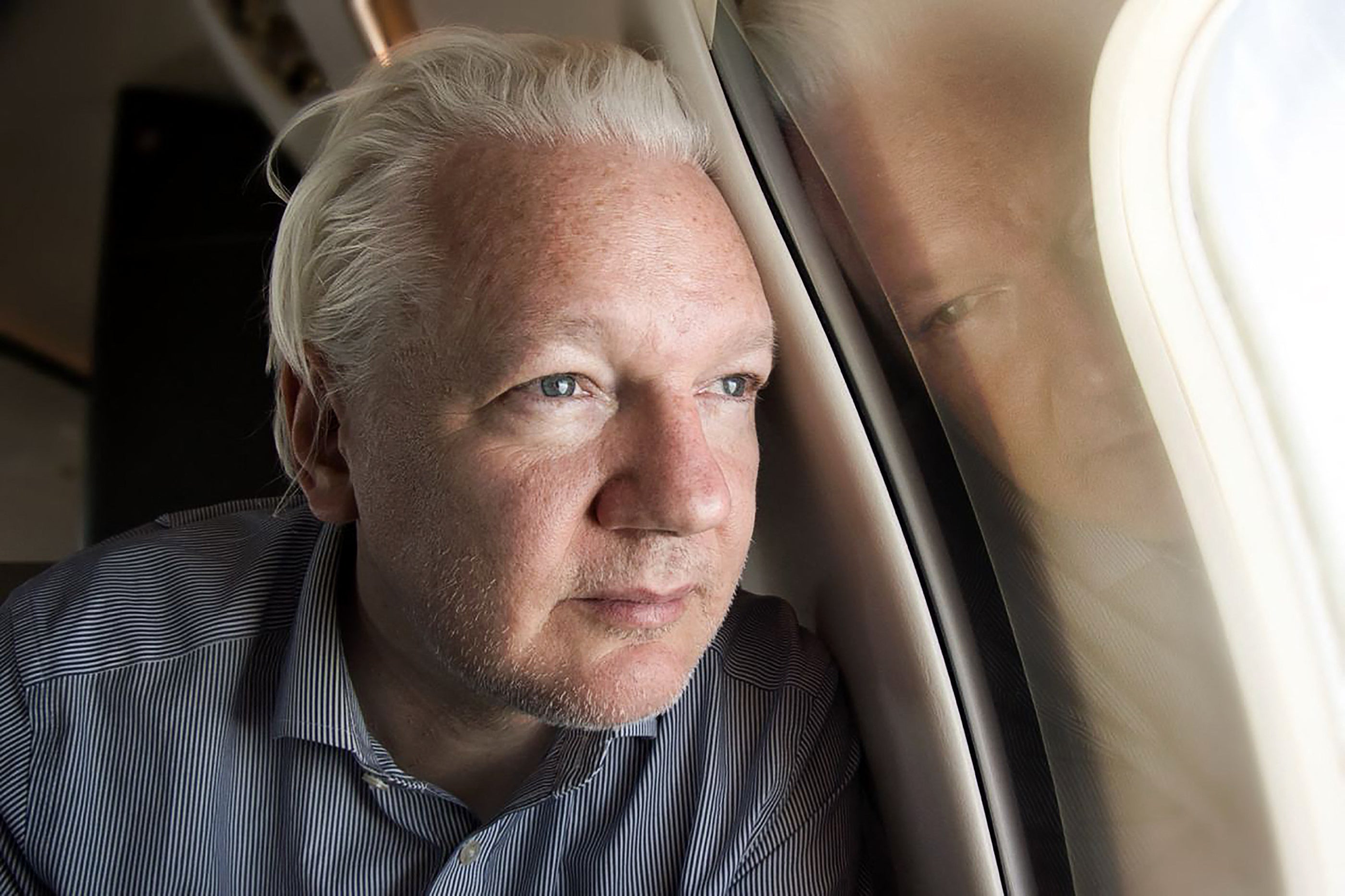 WikiLeaks founder Julian Assange looks out of the window as his plane from London approaches Bangkok airport