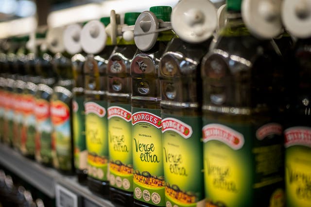 <p>Bottles of virgin olive oil, sealed with an anti-theft system, are photographed on a shelf in a shop in Barcelona, Spain</p>