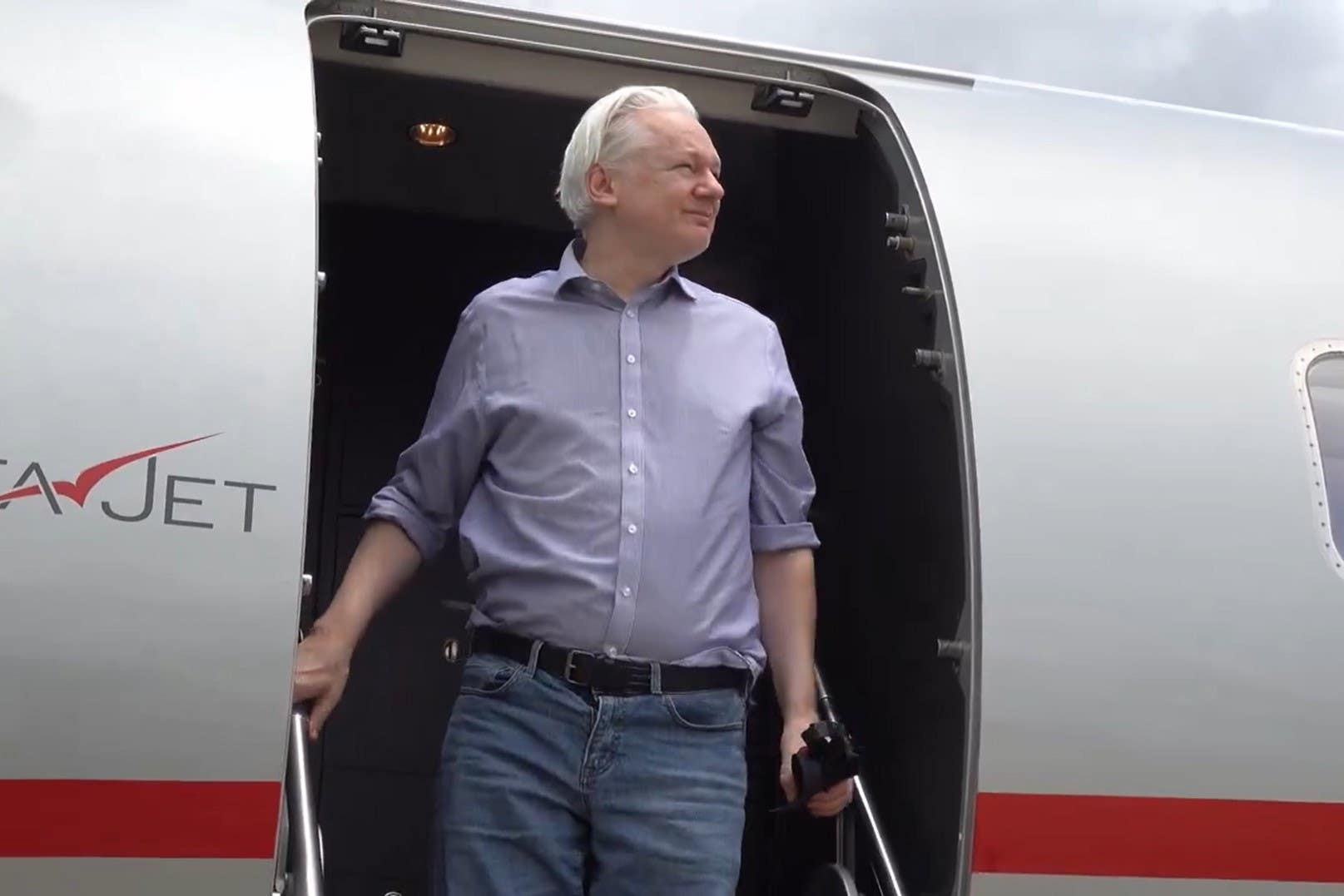 Assange arriving in Bangkok en route to the Mariana Islands