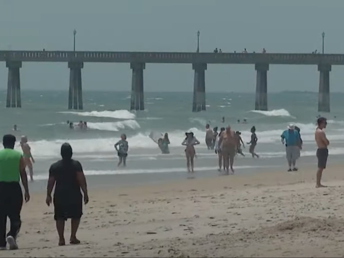 Beachgoers mill around the beach and play in the surf at Carolina Beach, North Carolina. More than 90 people had to be rescued from rip currents during the second-to-last weekend of June 2024 at the beach