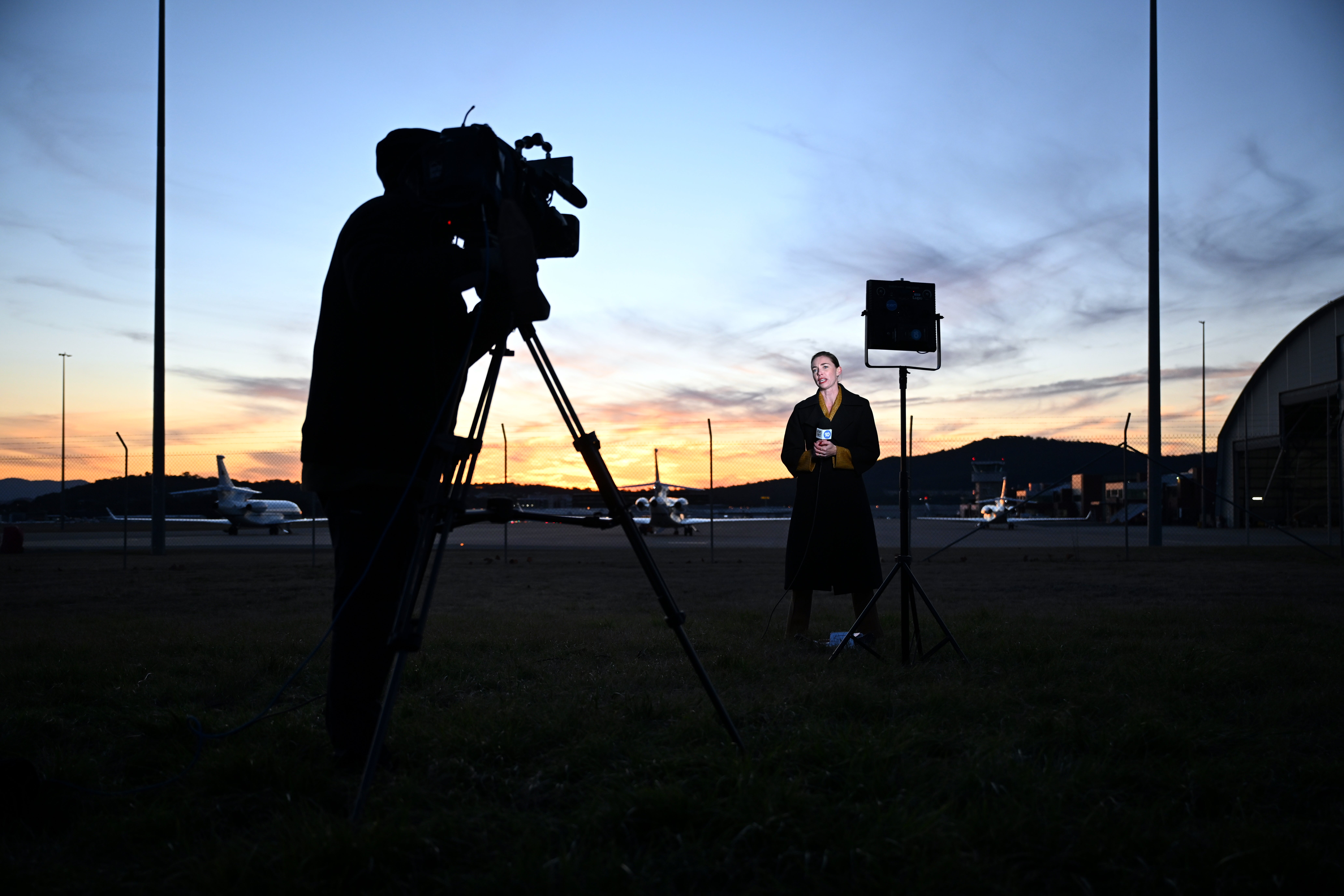 Members of the media during a live cross while waiting for the arrival of WikiLeaks founder Julian Assange at Fairbairn airbase at Canberra Airport