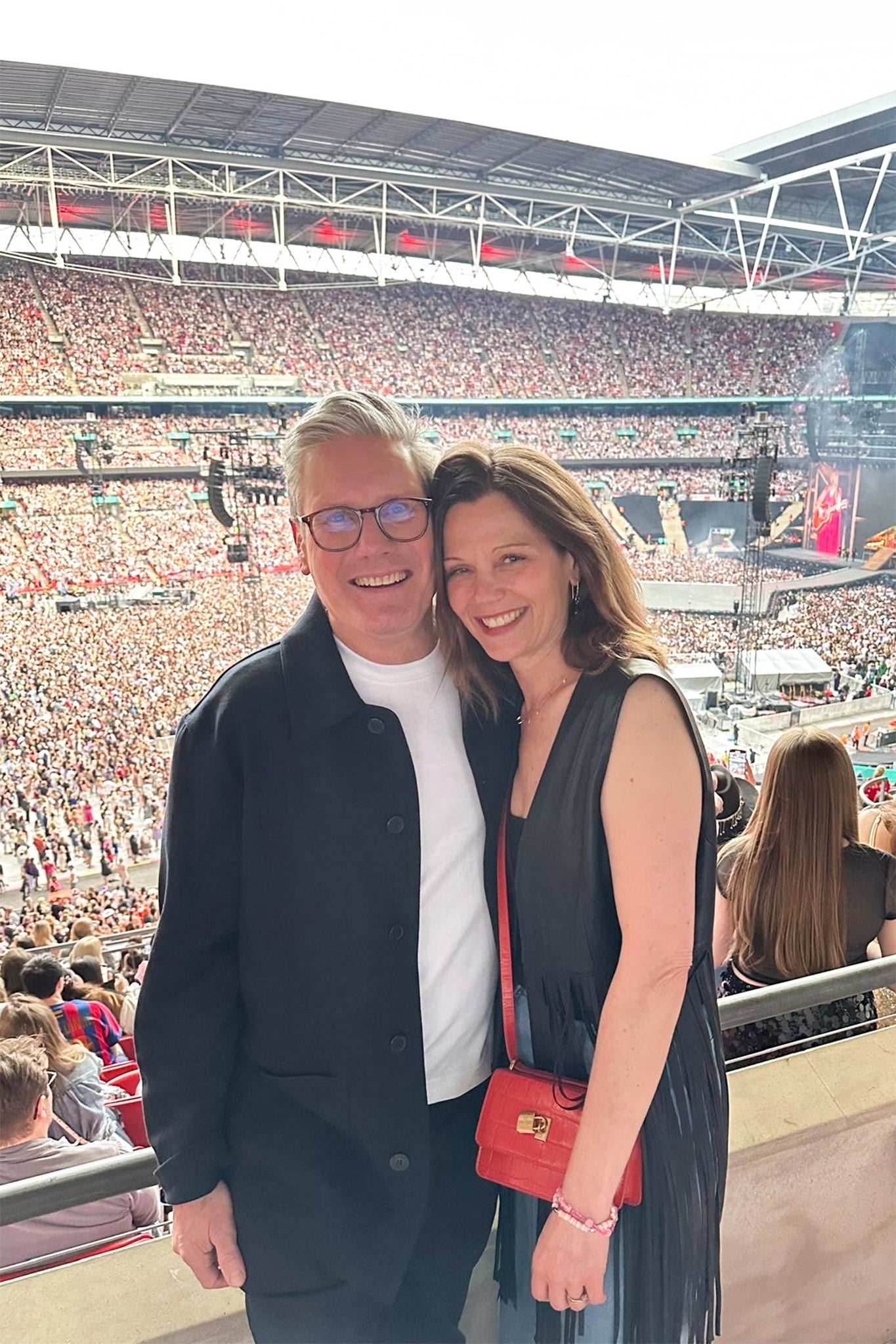 His rock: With wife Victoria at a Taylor Swift concert at Wembley