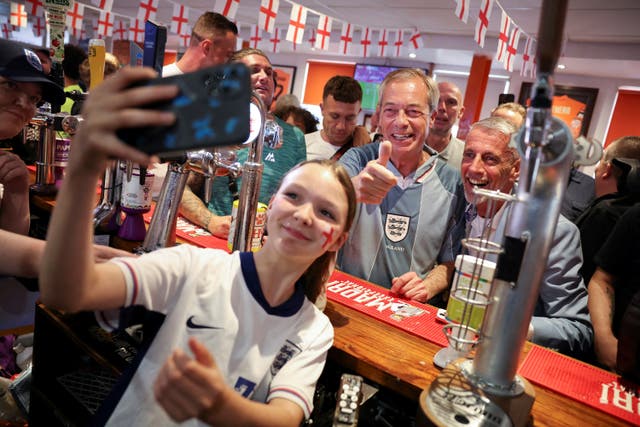 <p>Nigel Farage poses for pictures at a pub in Blackpool before England’s match against Denmark at Euro 2024 </p>