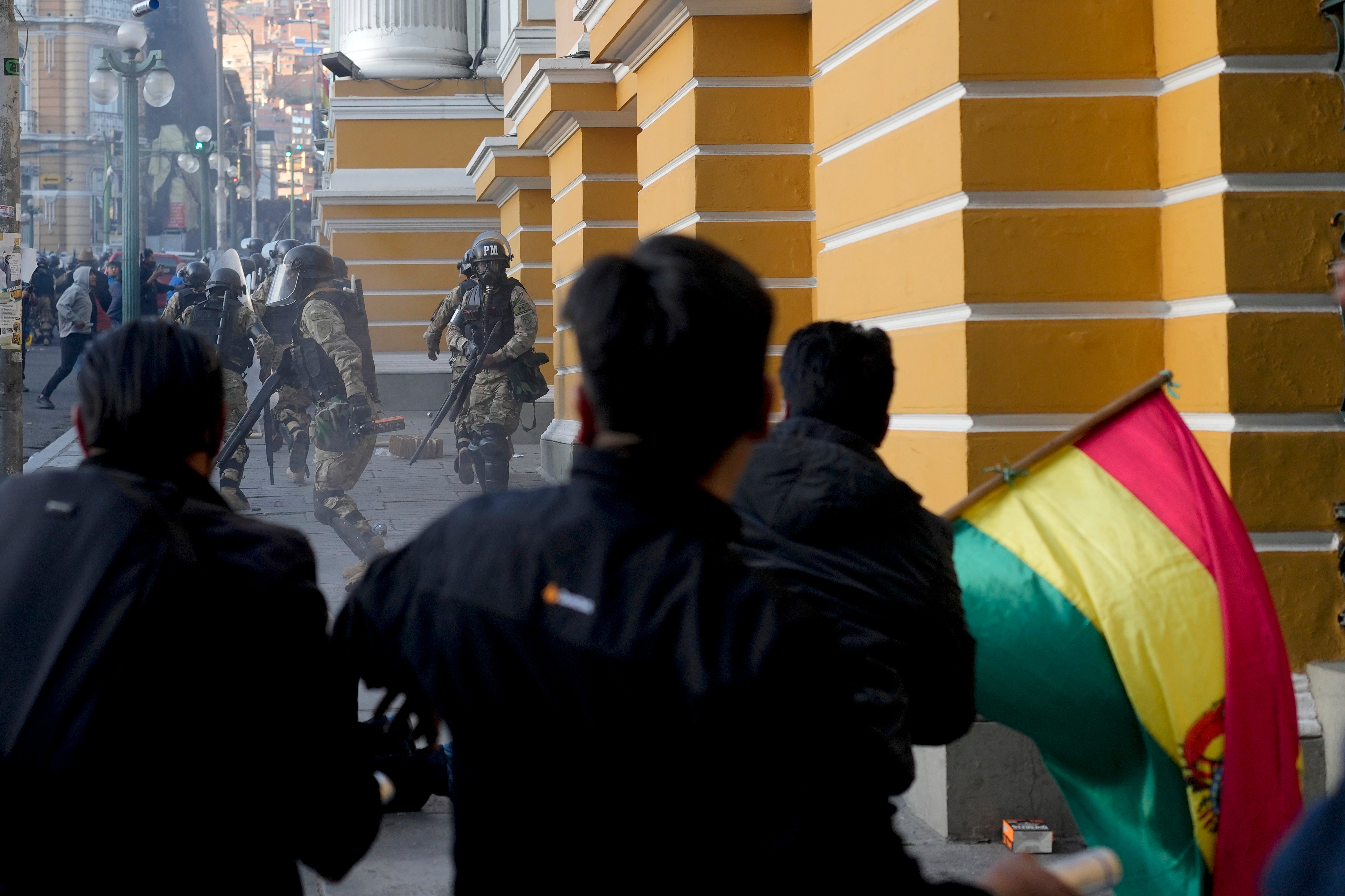 Supporters of President Luis Arce chase soldiers as they flee from Plaza Murillo, after a failed coup attempt in La Paz, Bolivia, Wednesday, June 26, 2024