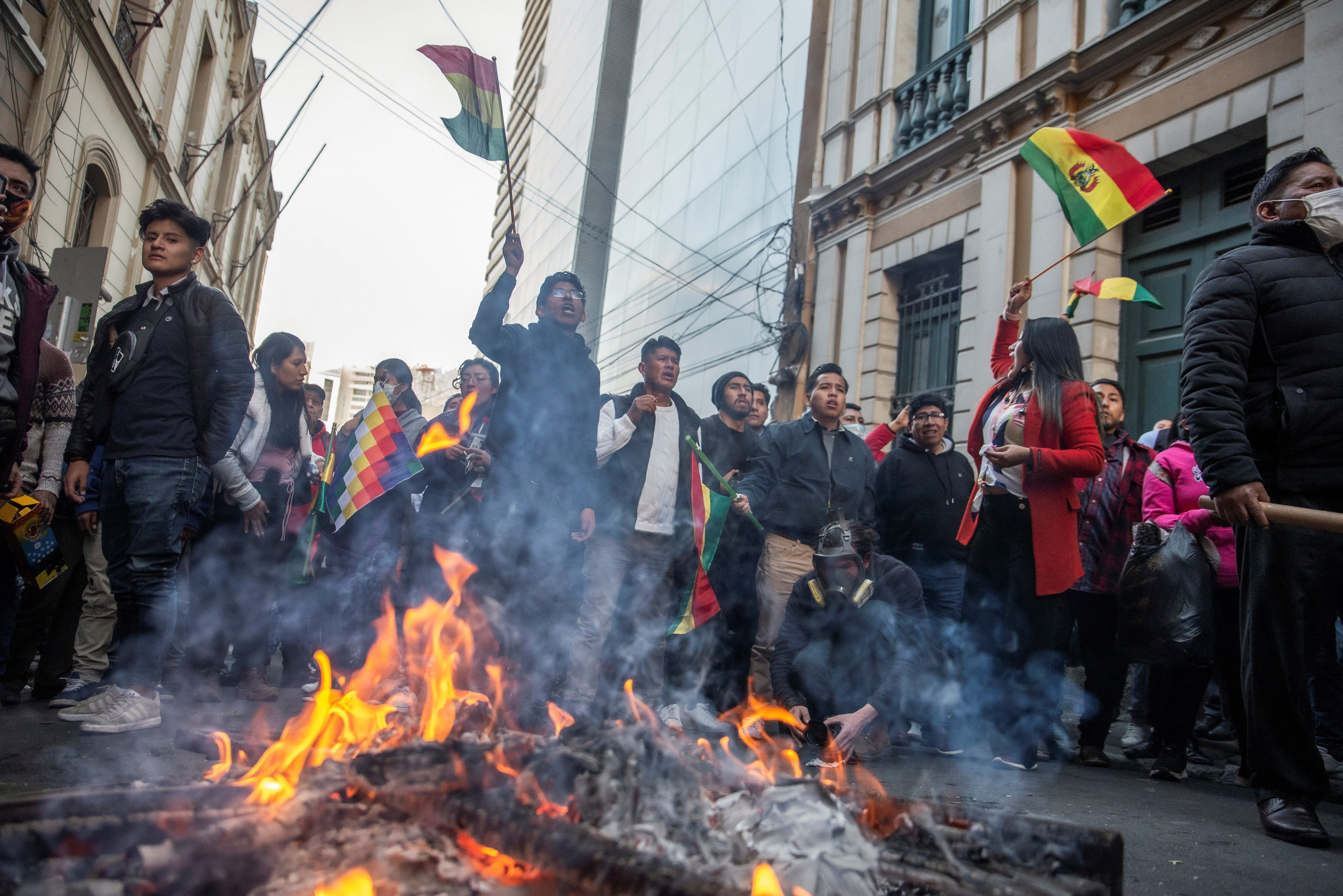 Lidé mávají státní vlajkou Bolívie a křičí na vojenskou policii během pokusu o puč proti vládě bolivijského prezidenta Luise Arceho vojenskými jednotkami.