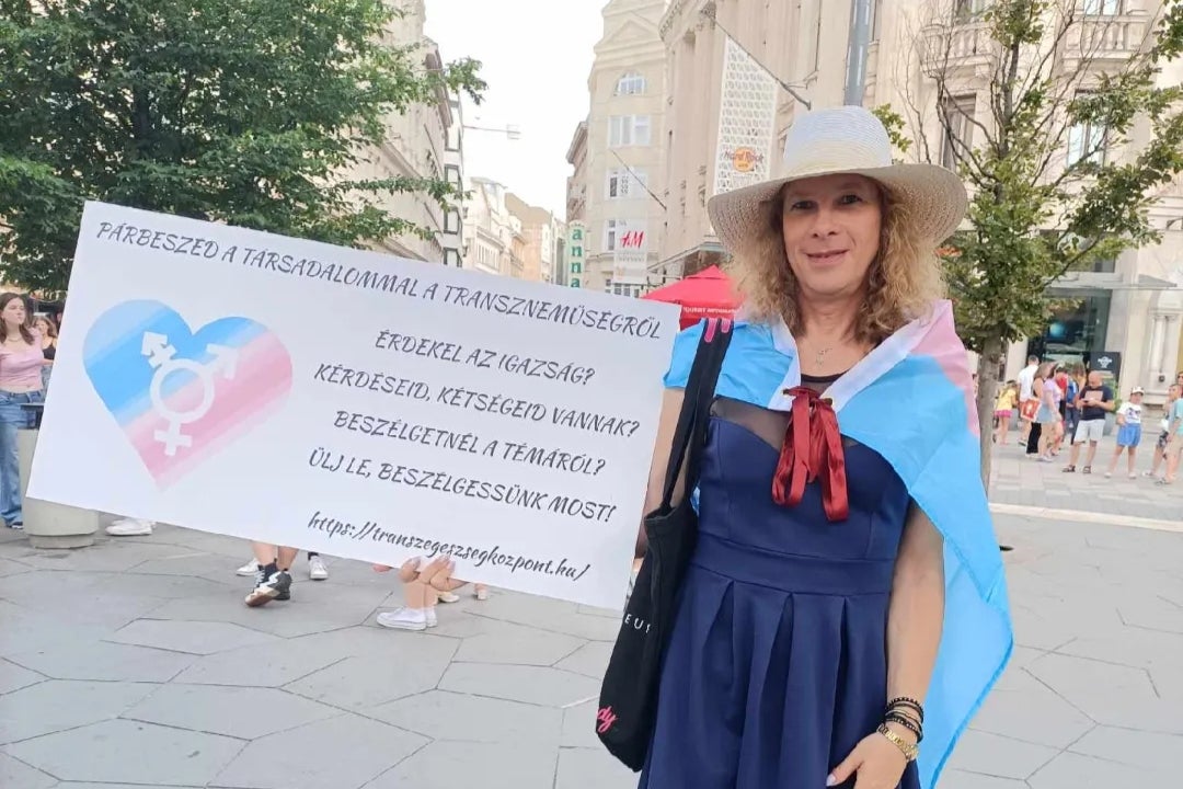 Monika Magashazi holds up a sign in central Budapest inviting locals to ask her about transgender rights in a bid to combat a ban on LGBT+ education