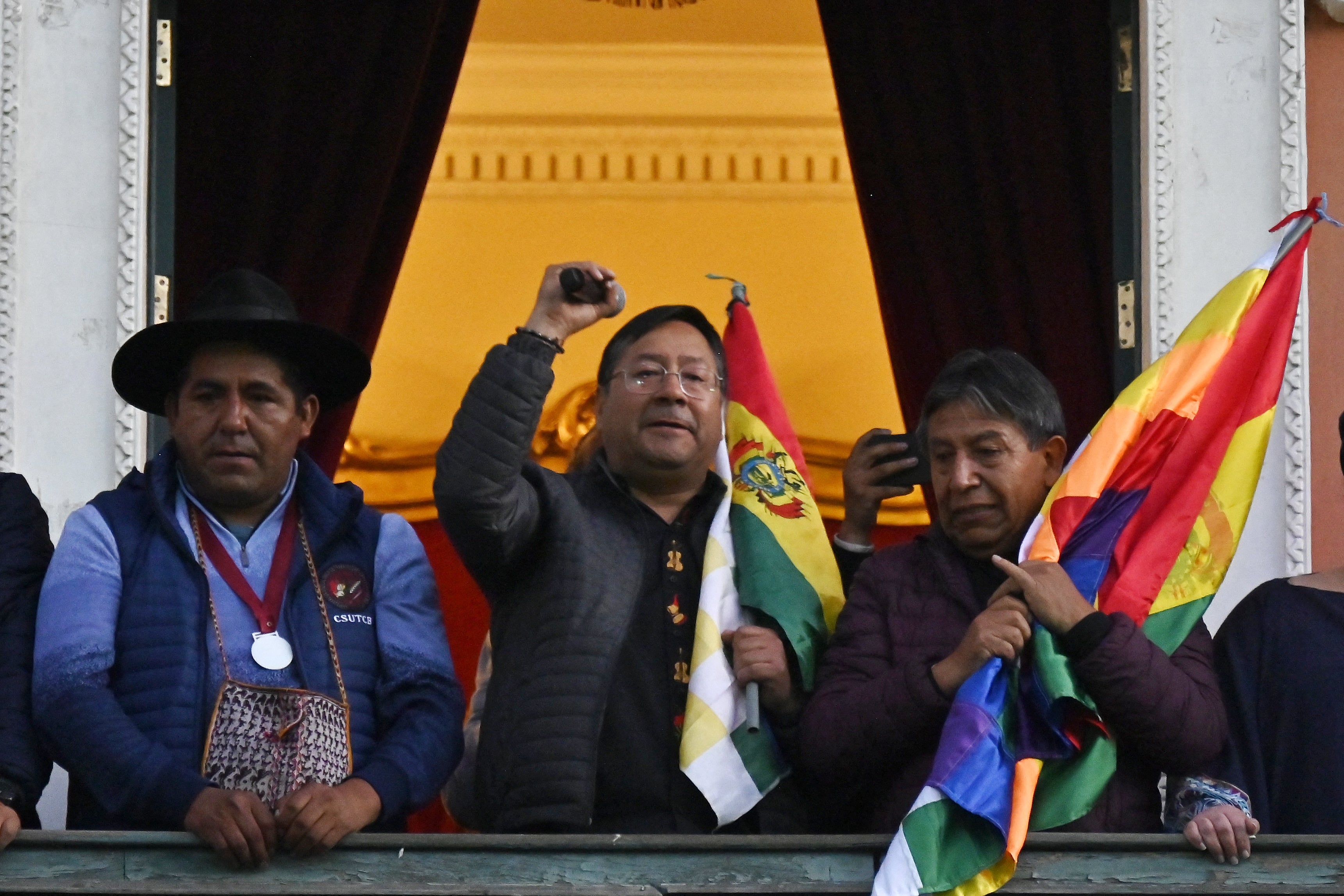O presidente boliviano Luis Arce (centro) fala da varanda do Palácio do Governo em La Paz