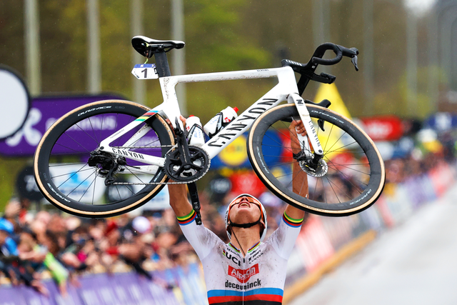 <p>Mathieu van der Poel raises his bike in triumph at the finish of the Tour of Flanders</p>