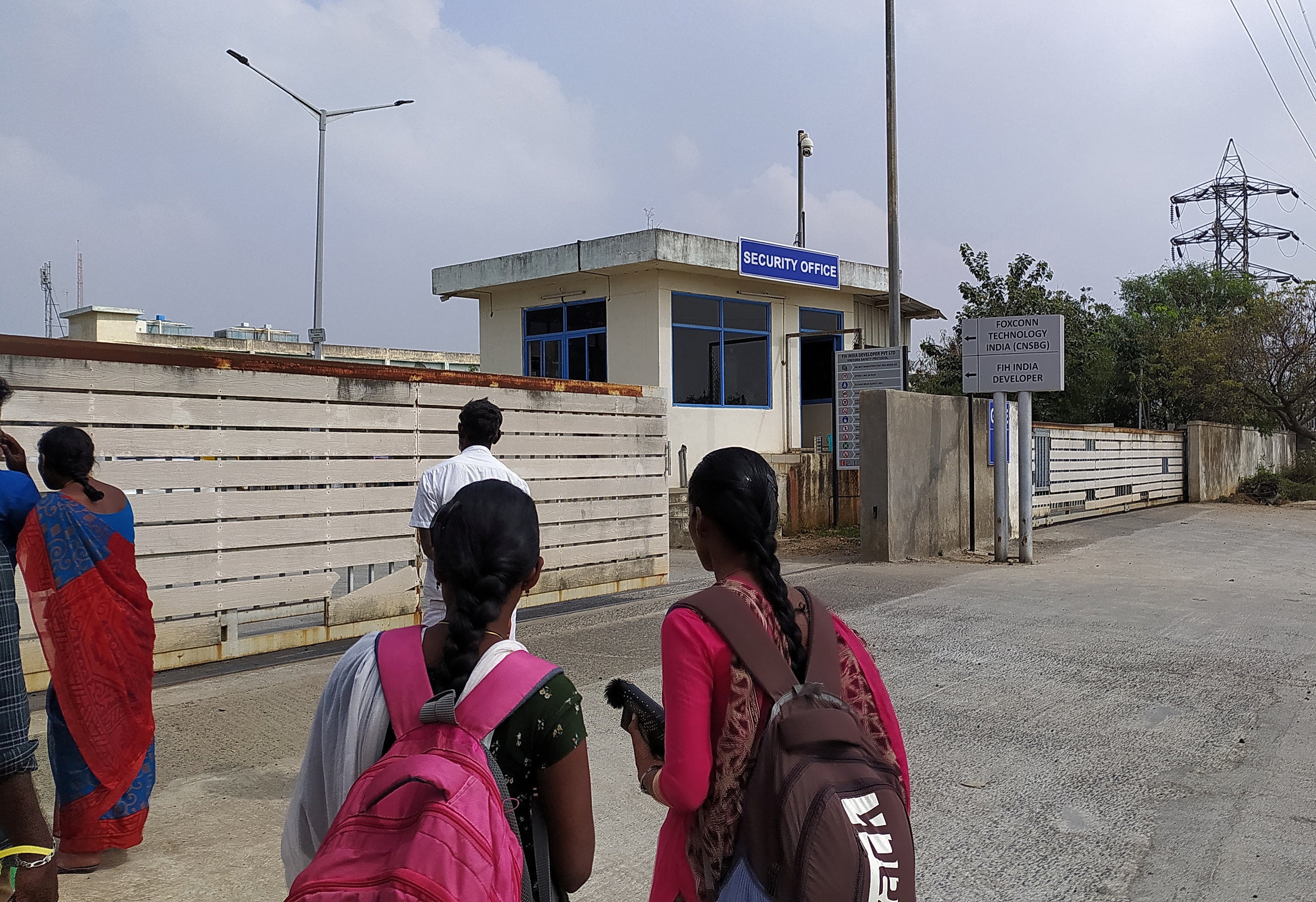 Two unidentified women stand outside Foxconn's factory in Sriperumbudur near Chennai
