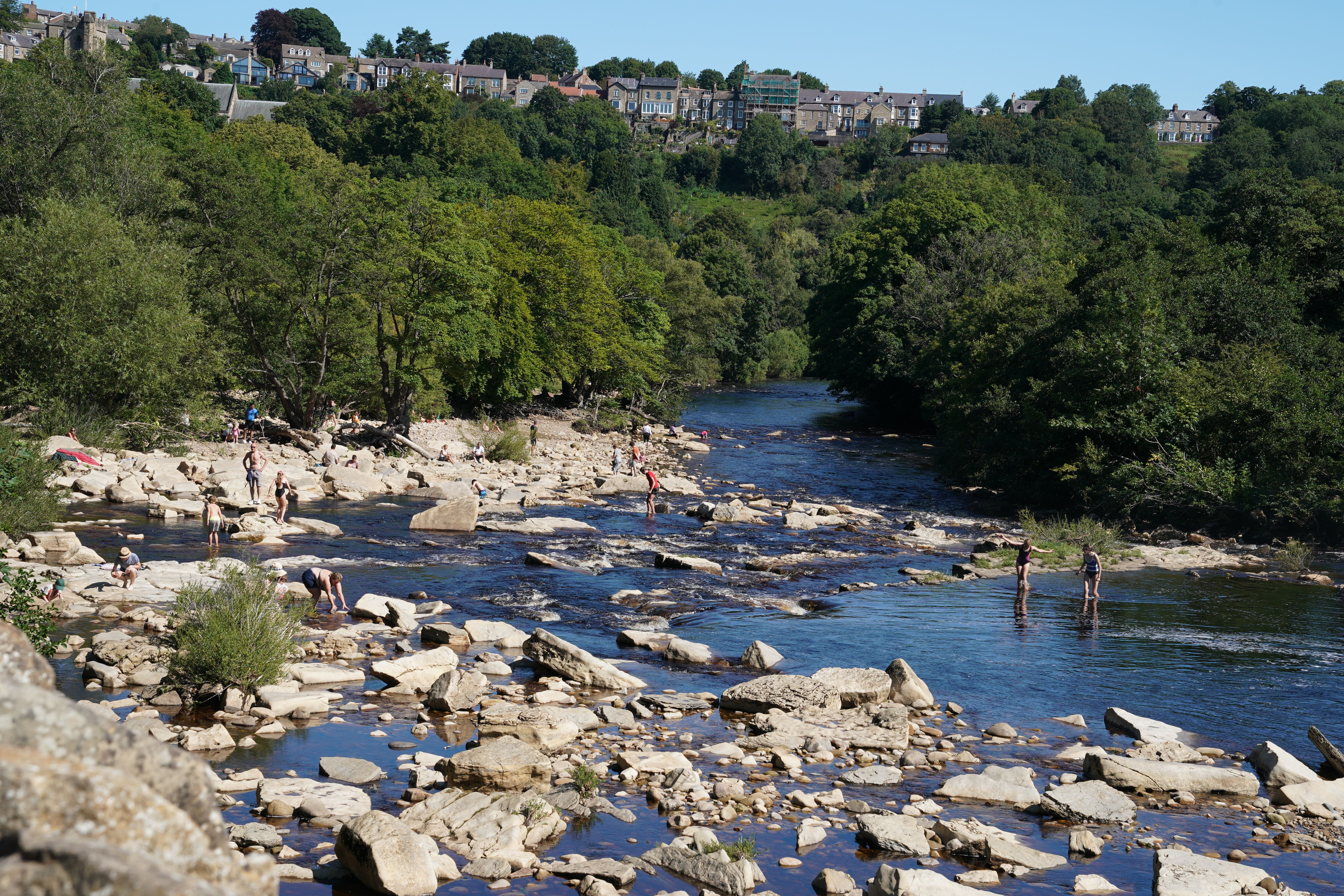 People enjoy hot weather at Richmond Falls on the River Swale, North Yorkshire (Owen Humphreys/PA)