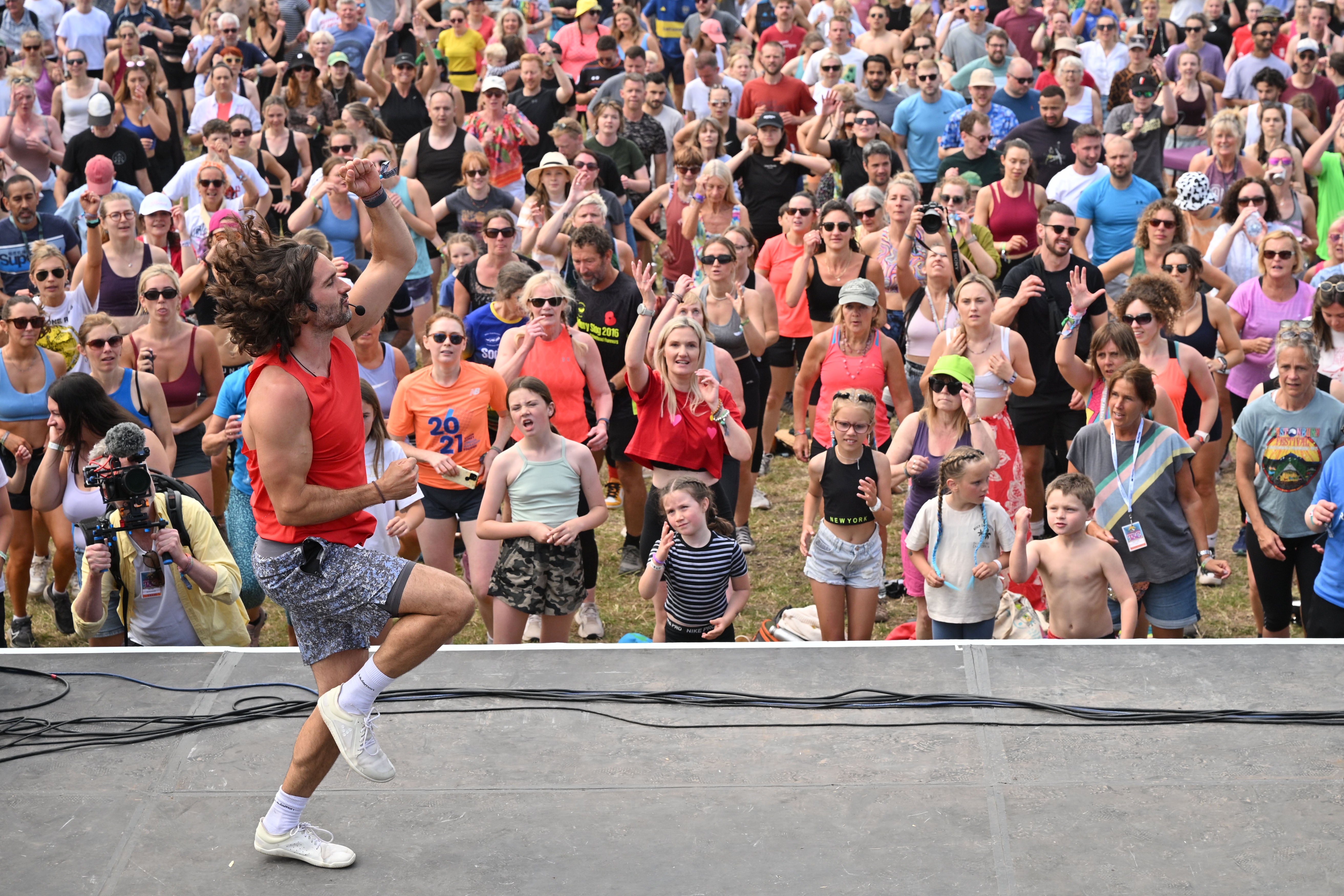 knee up!  Joe Wicks instructs the crowd as he leads Glastonbury rehearsals