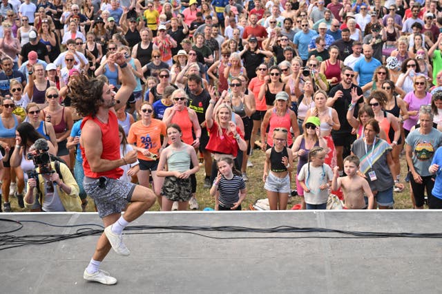 <p>Knees up! Joe Wicks instructs the crowd as he leads a Glastonbury workout</p>