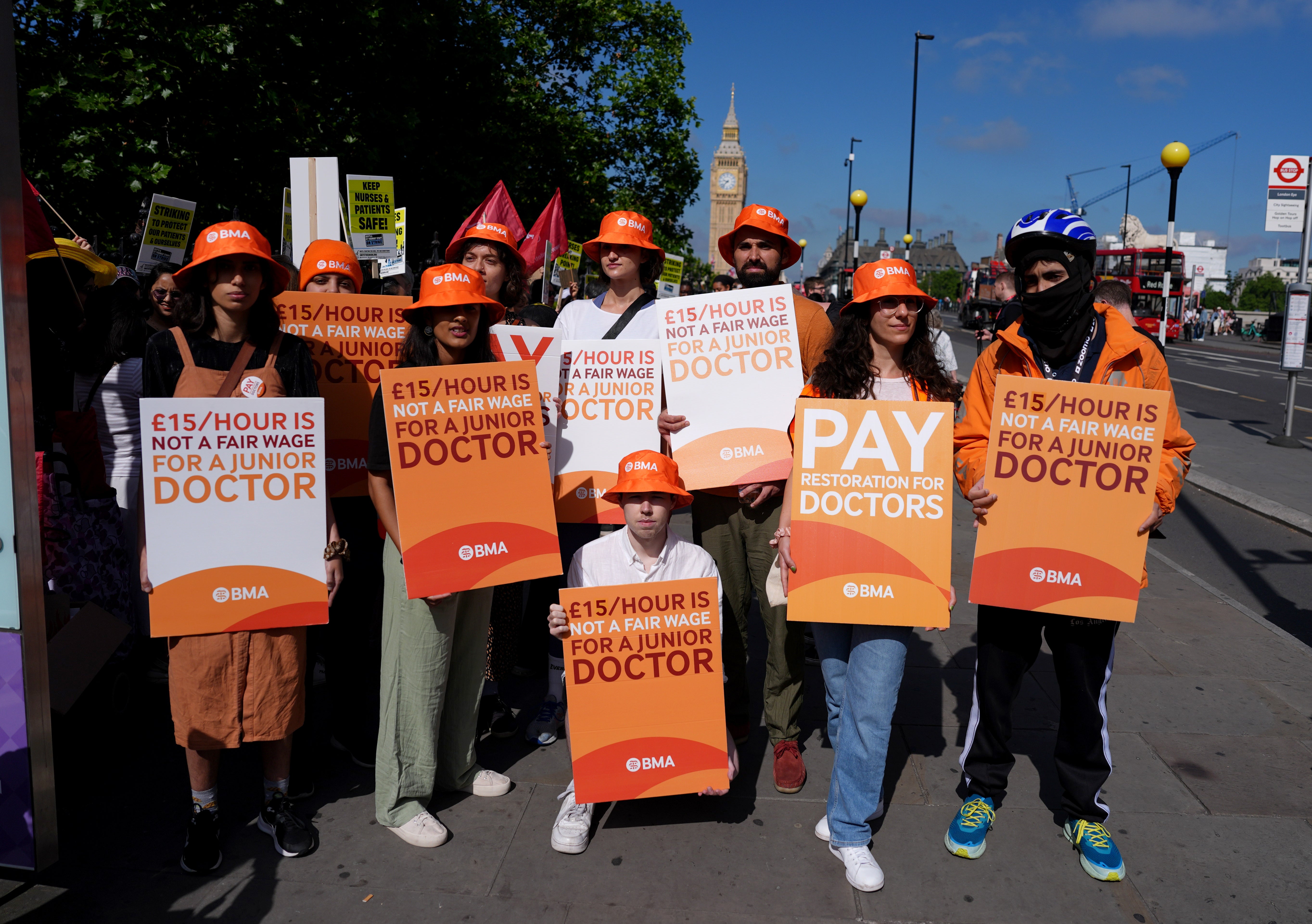 Junior doctors, joined by a Just Eat delivery courier, right, on the picket line outside St Thomas’ Hospital in London (Jordan Pettitt/PA)