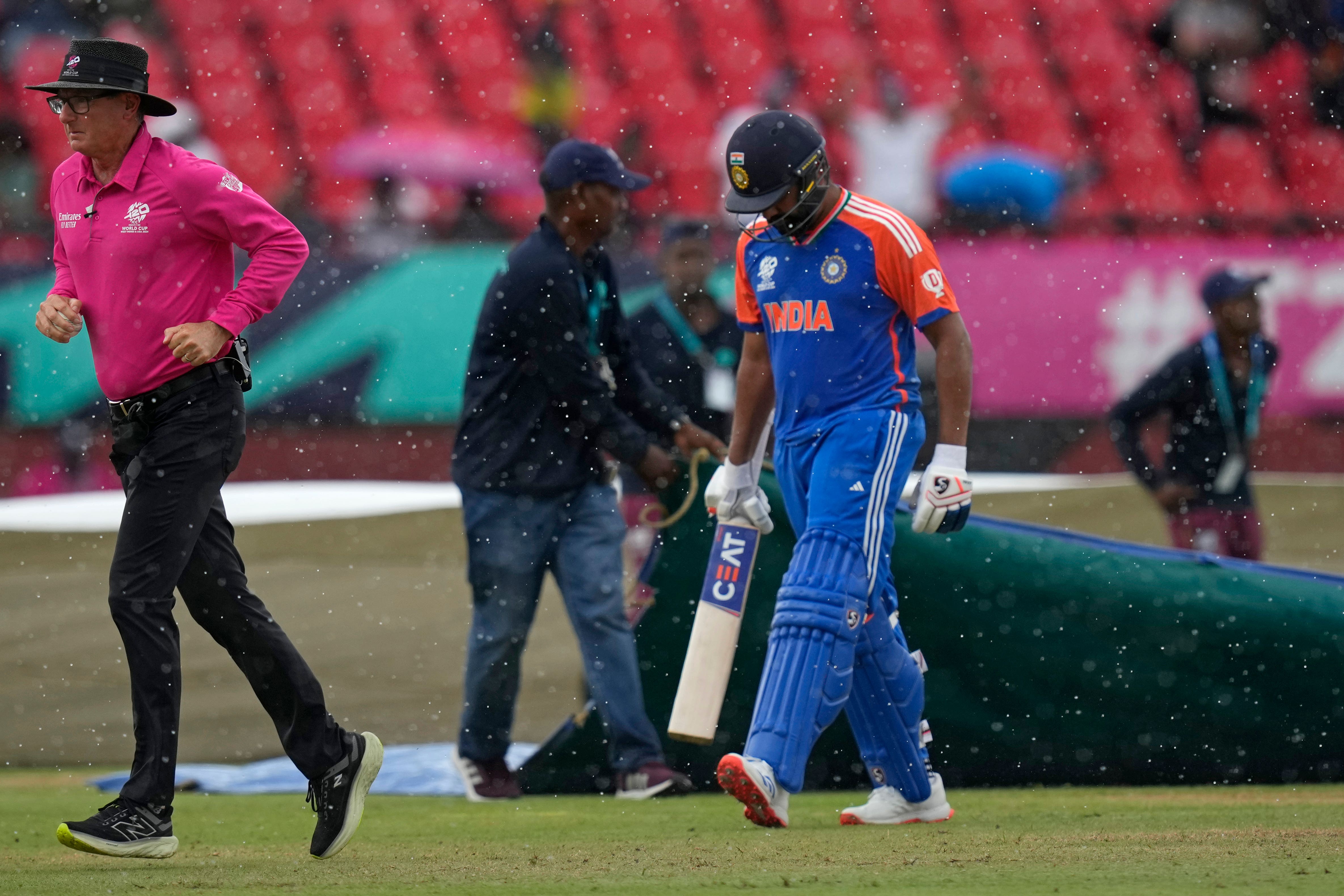 Rohit Sharma, right, leaves the field after rain stopped play (AP/Ramon Espinosa)