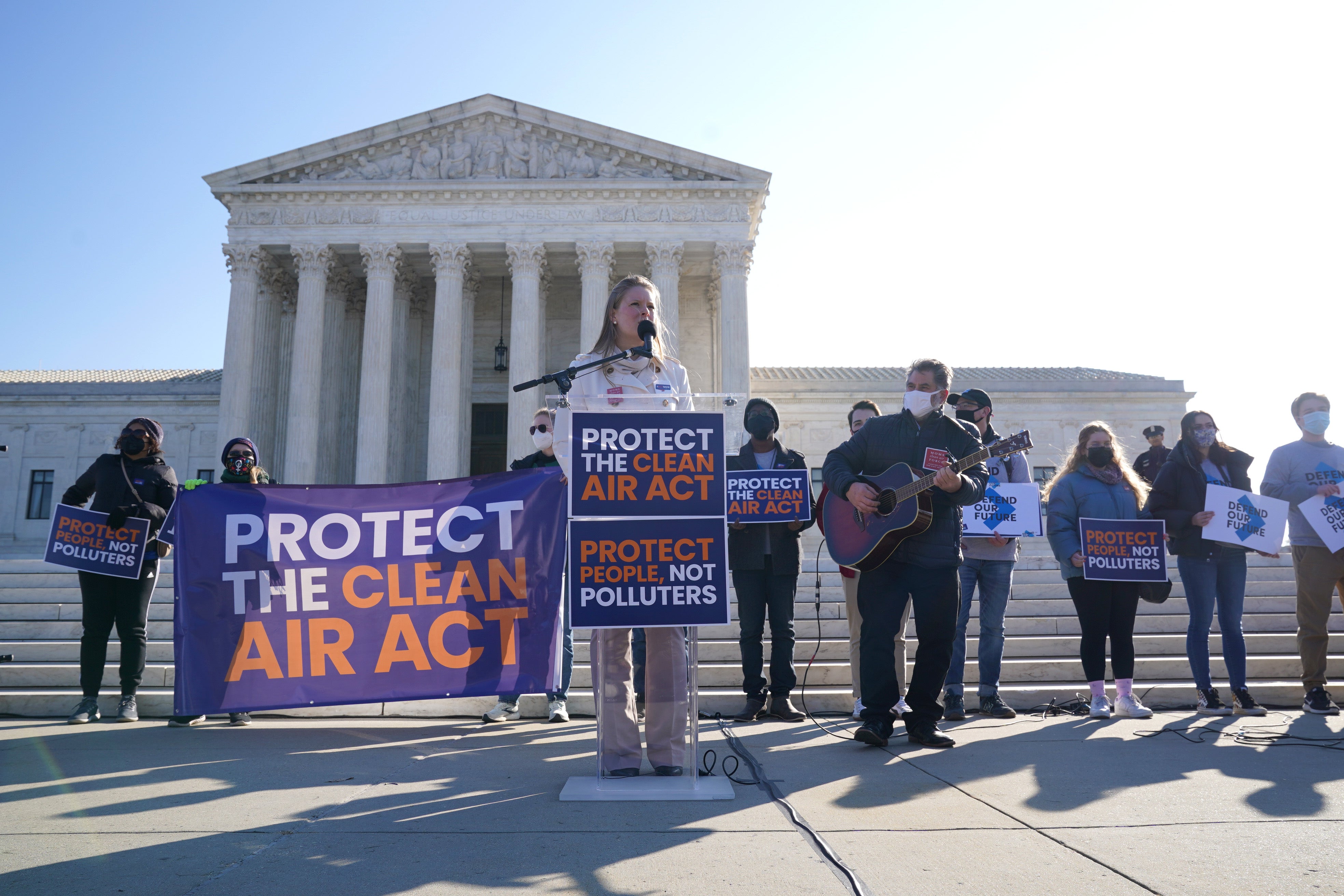 Singer Lucia Valentine performs outside as the Supreme Court hears from coal companies and their partisan allies who are trying to gut the Clean Air Act and block climate action. Barrett was suprised when she sided with the court’s liberal judge’s in the ruling
