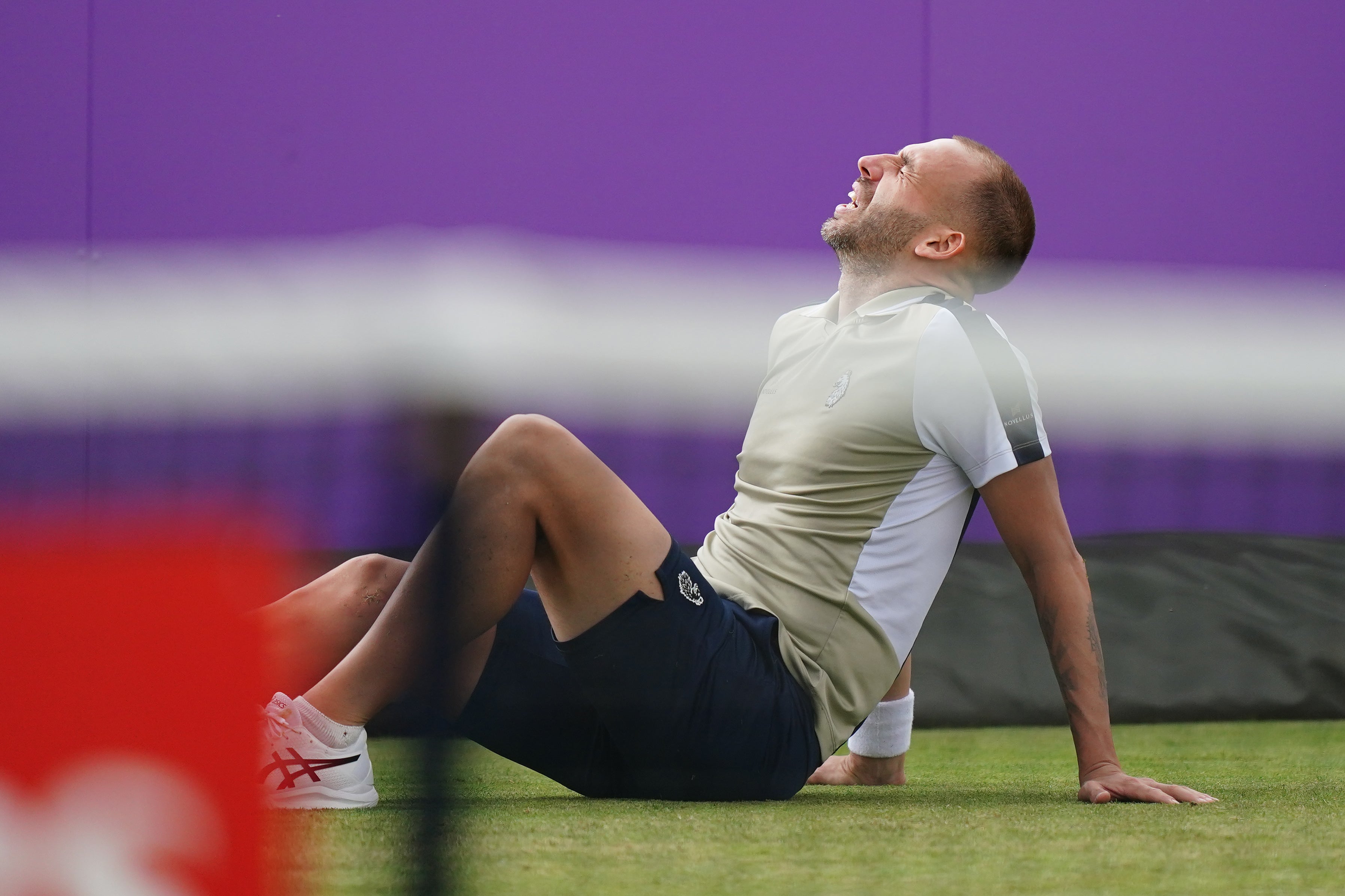 Evans reacts after slipping and hurting his knee at Queen’s Club (Zac Goodwin/PA)
