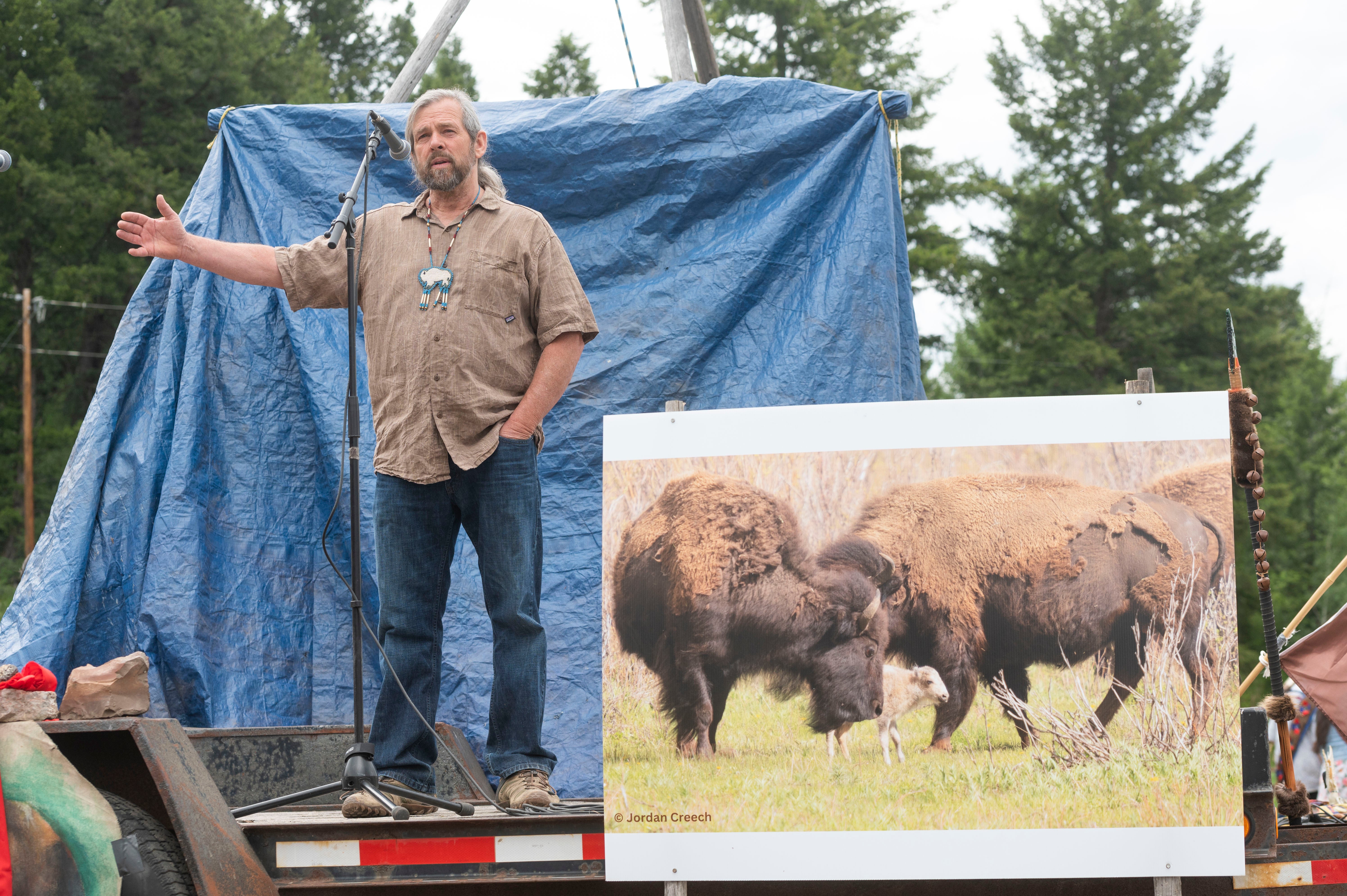 Mike Mease, co-founder of the Buffalo Field Campaign, speaks next to a photograph of a white buffalo calf during a naming ceremony for the recently born calf.
