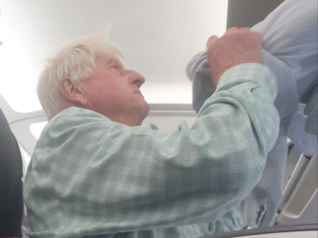 <p>Departing soon: Stanley Johnson preparing to leave British Airways flight 2461 from Malaga, which was diverted to Heathrow</p>