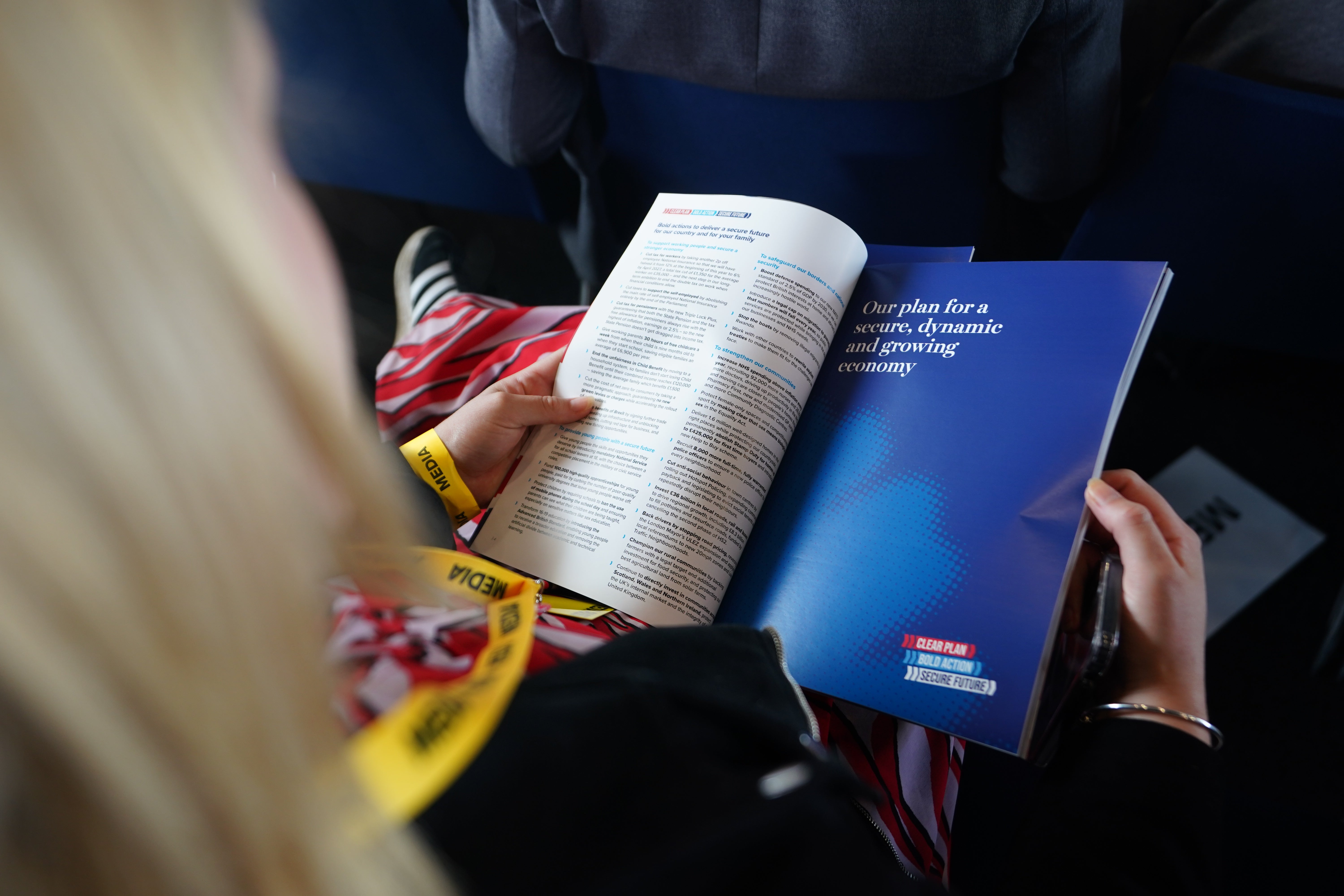 A member of the audience holds a copy of the Conservative Party General Election manifesto (James Manning/PA)
