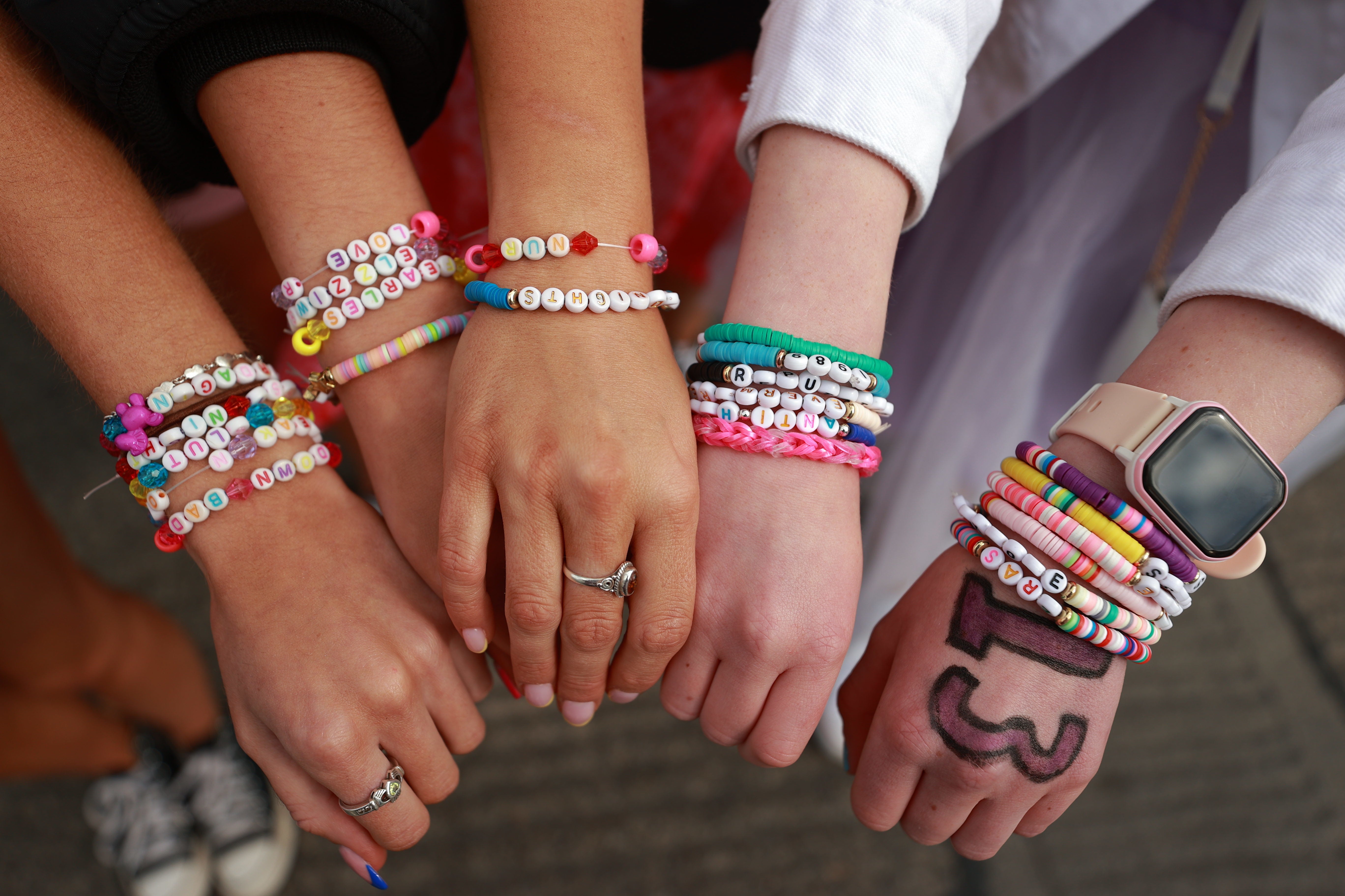 (Left to right) Sisters Erin O Geran, Orla O Geran, Eadaoin O Geran and Emma Tobin from Cork show their friendship bracelets before watching Taylor Swift performing on stage at the Aviva Stadium in Dublin (Liam McBurney/PA)