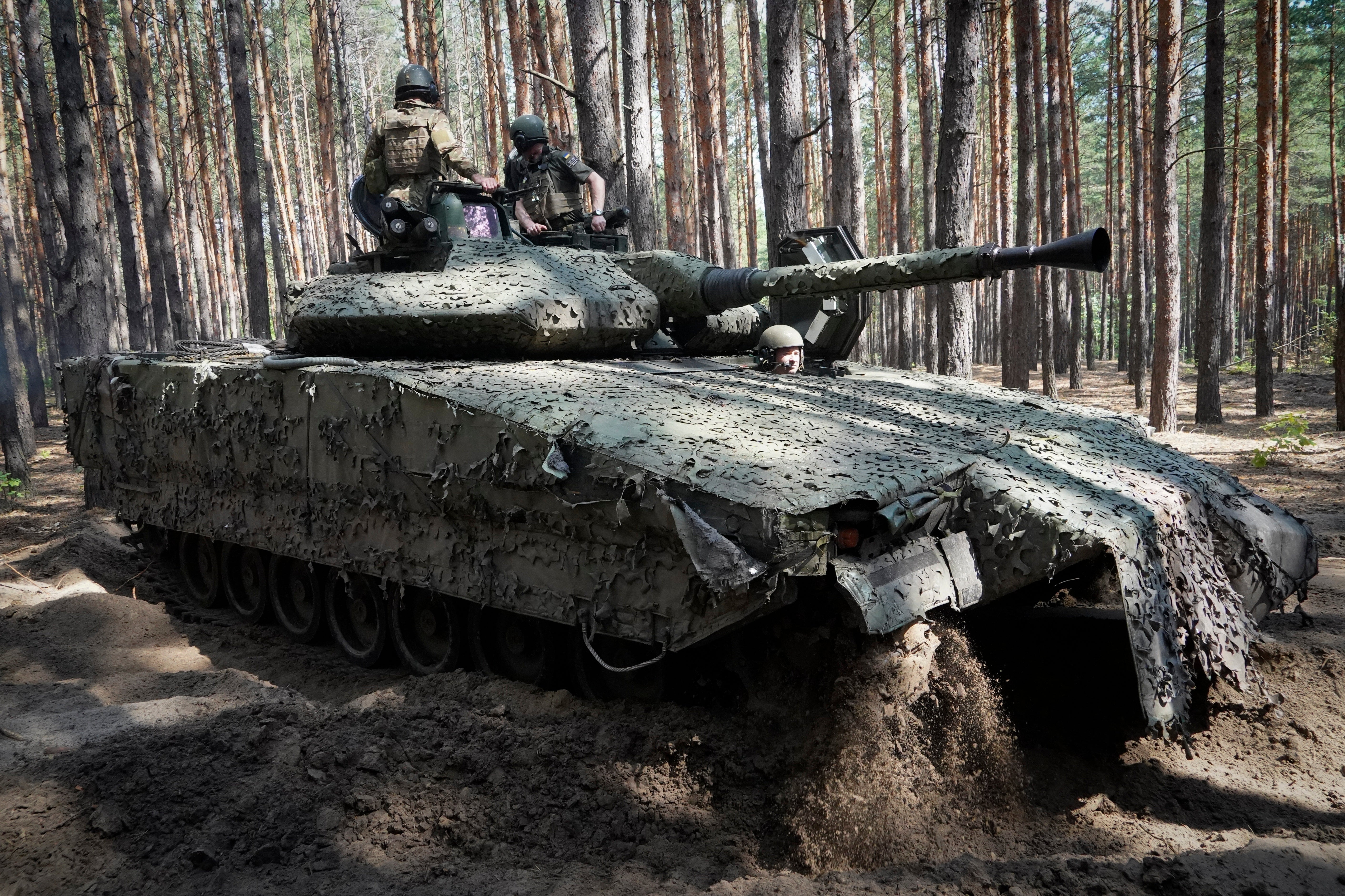 Ukrainian soldiers ride in a combat vehicle near the front line in the Kharkiv region