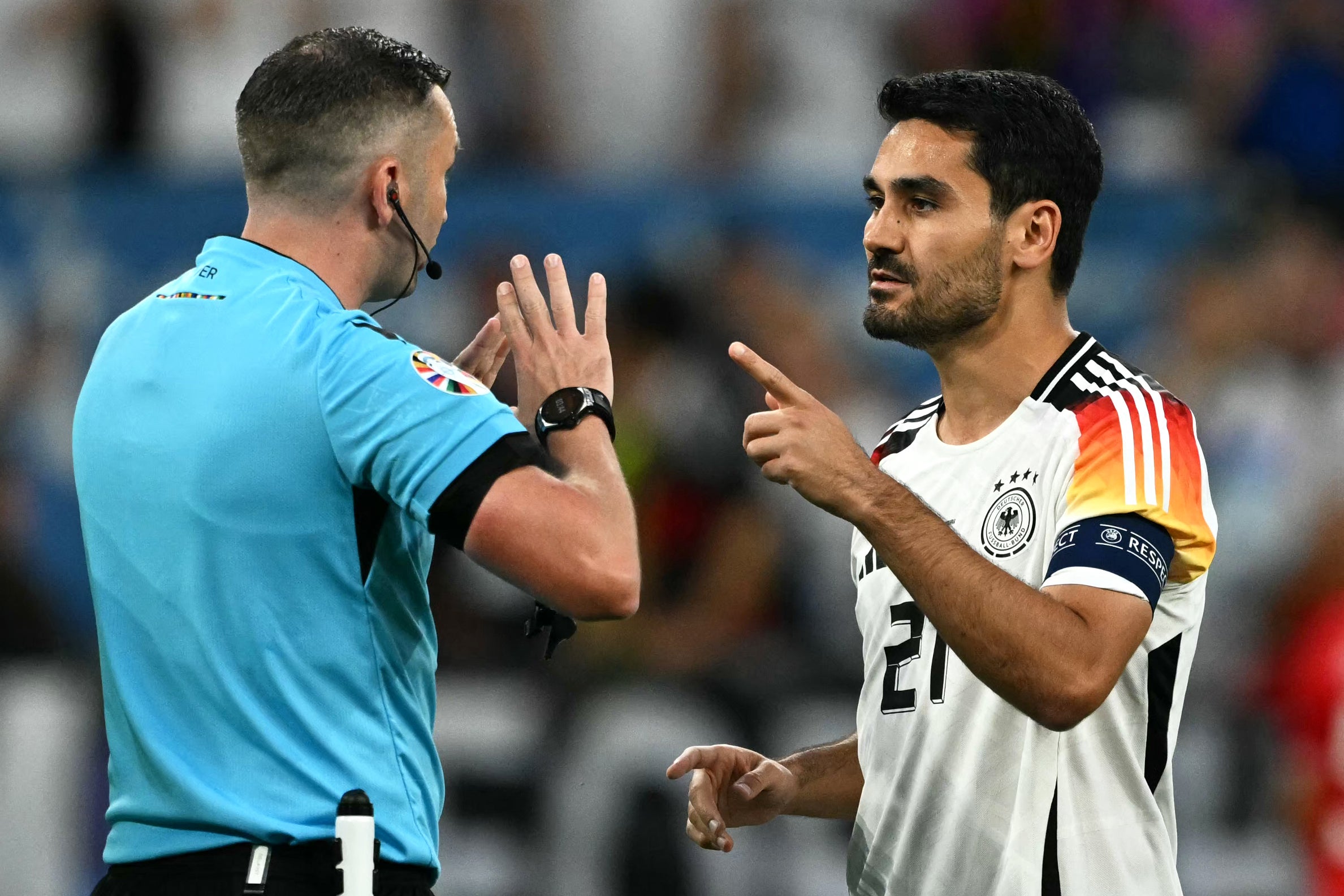 Michael Oliver discusses the finer points of the game with captain Ilkay Gundogan