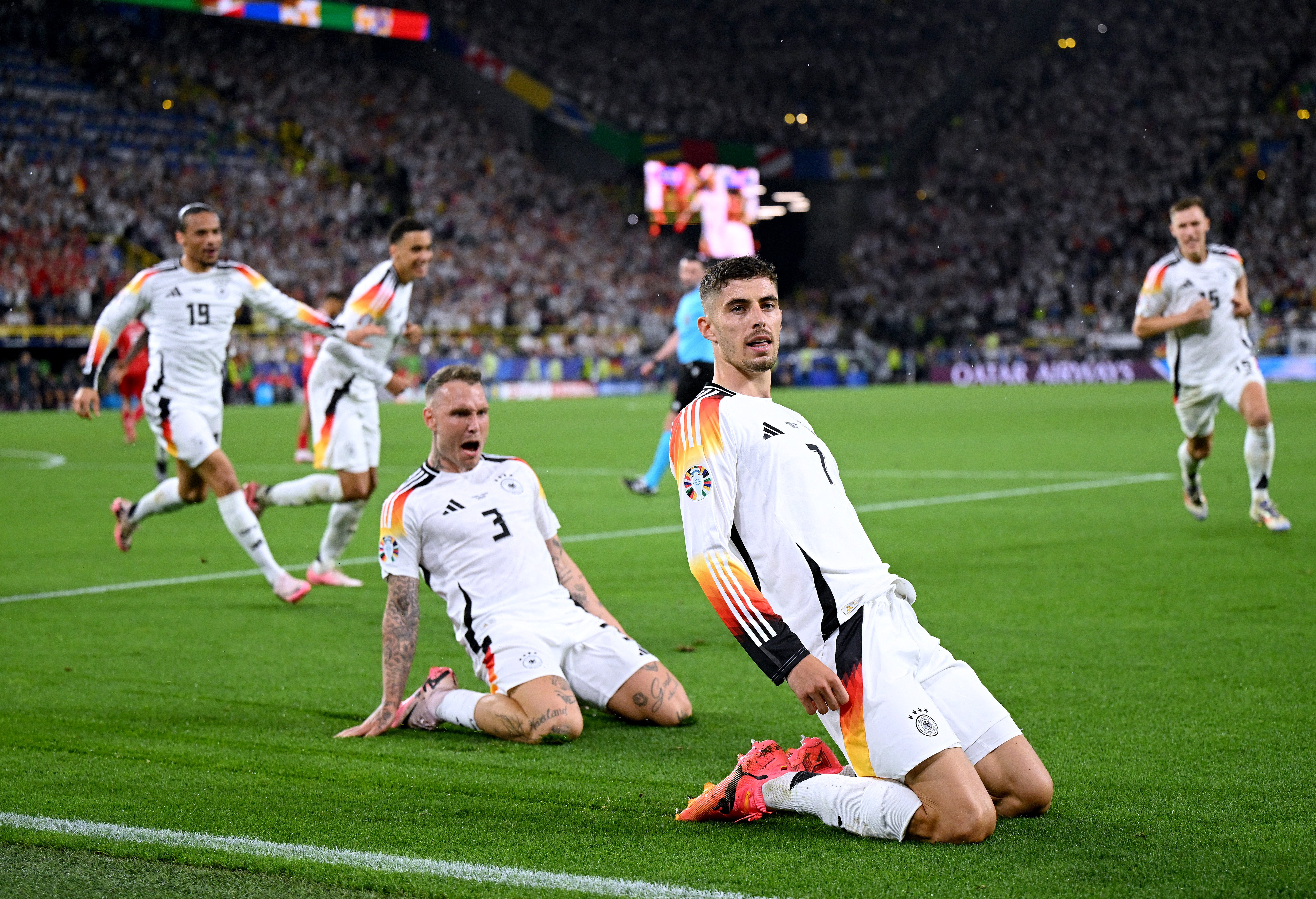 Kai Havertz slides in celebration after Germany scored against Denmark