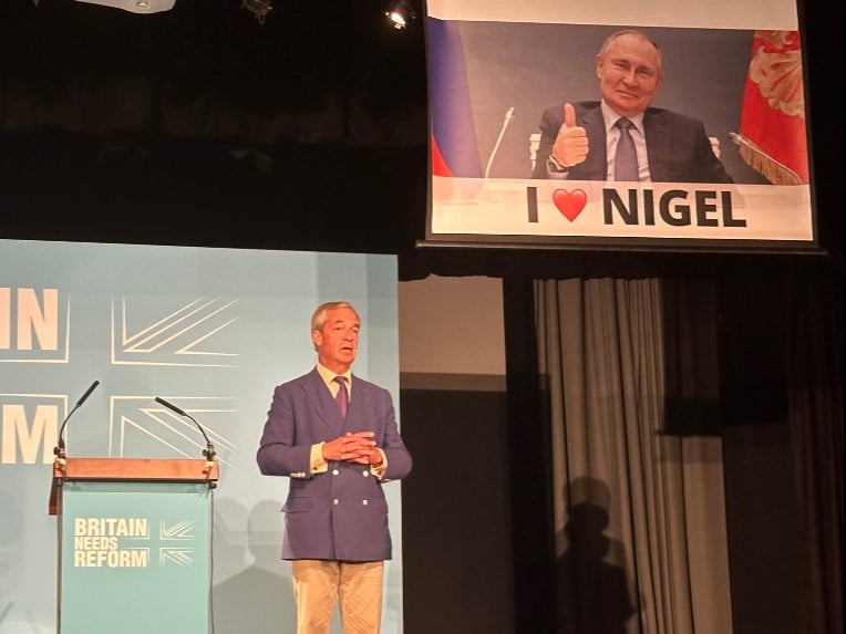 Nigel Farage was speaking as a banner of Putin was lowered behind him