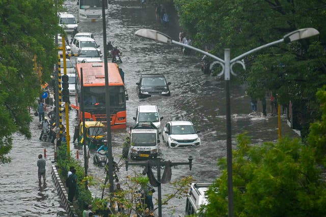 <p>Vehicles wade through flooded streets after heavy rains in New Delhi on 28 June 2024</p>