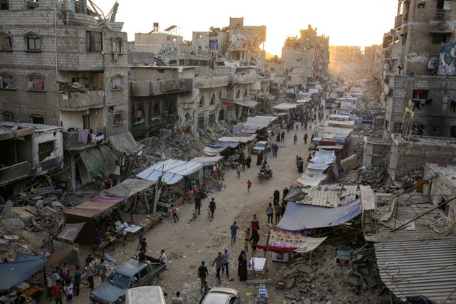 <p>Palestinians displaced by the Israeli bombardment of Gaza walk in Khan Younis on 29 June 2024</p>