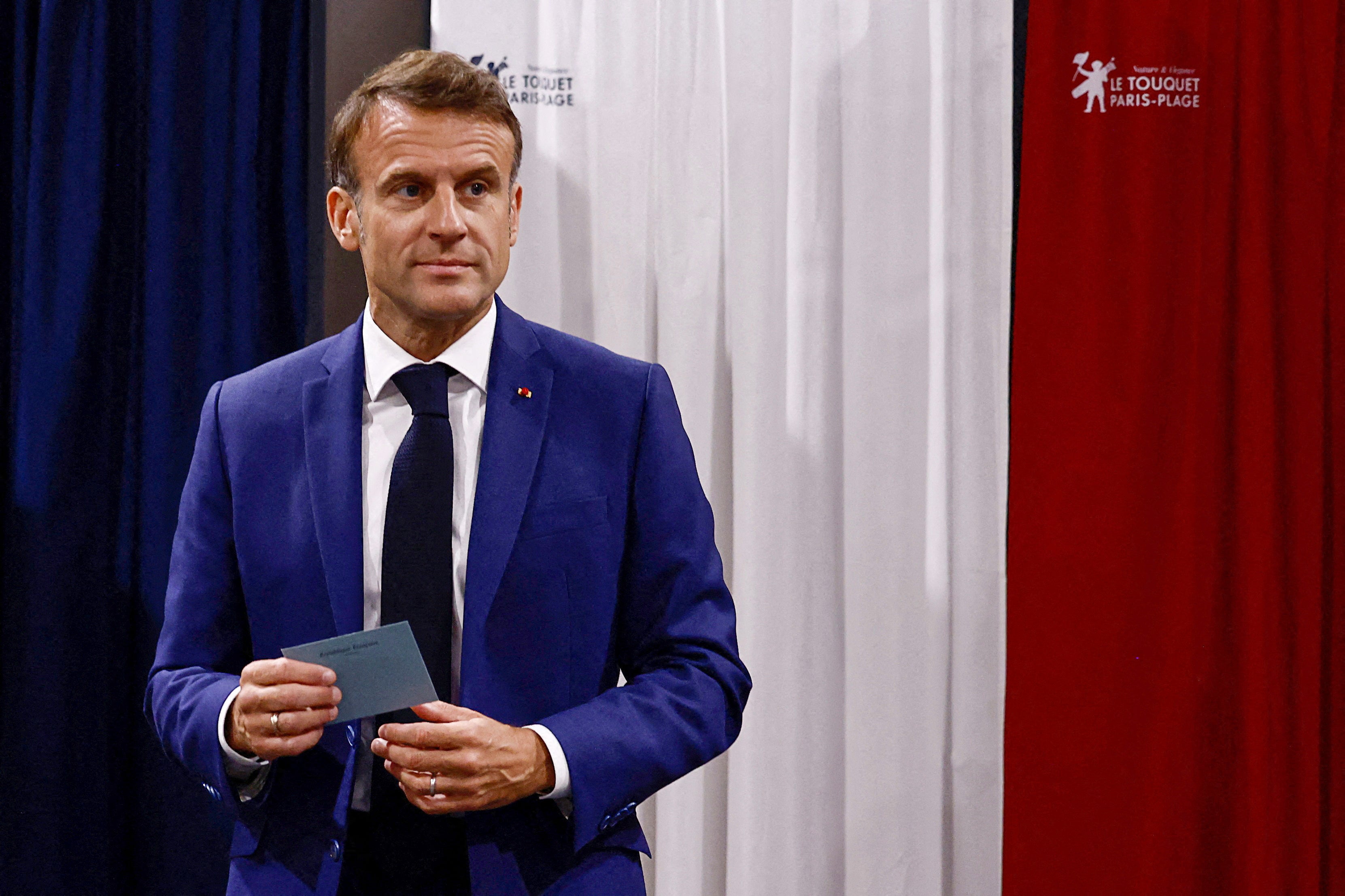 France's President Emmanuel Macron leaves the polling booth prior to cast his vote in the first round of parliamentary elections at a polling station in Le Touquet, northern France