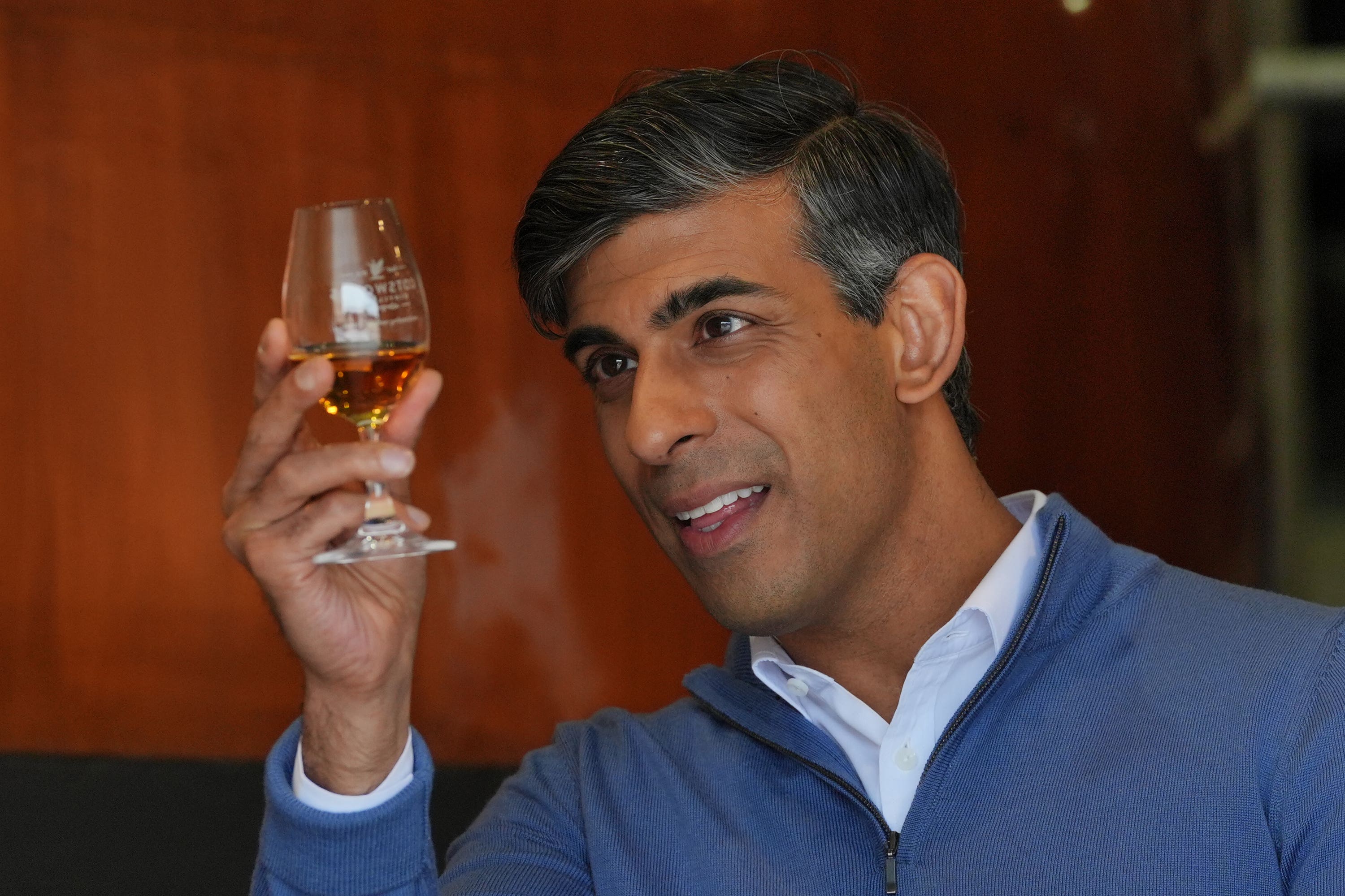 Prime Minister Rishi Sunak looks at a single malt whisky during a visit to the Cotswolds Distillery in Shipston-on-Stour, Warwickshire (Jonathan Brady/PA)