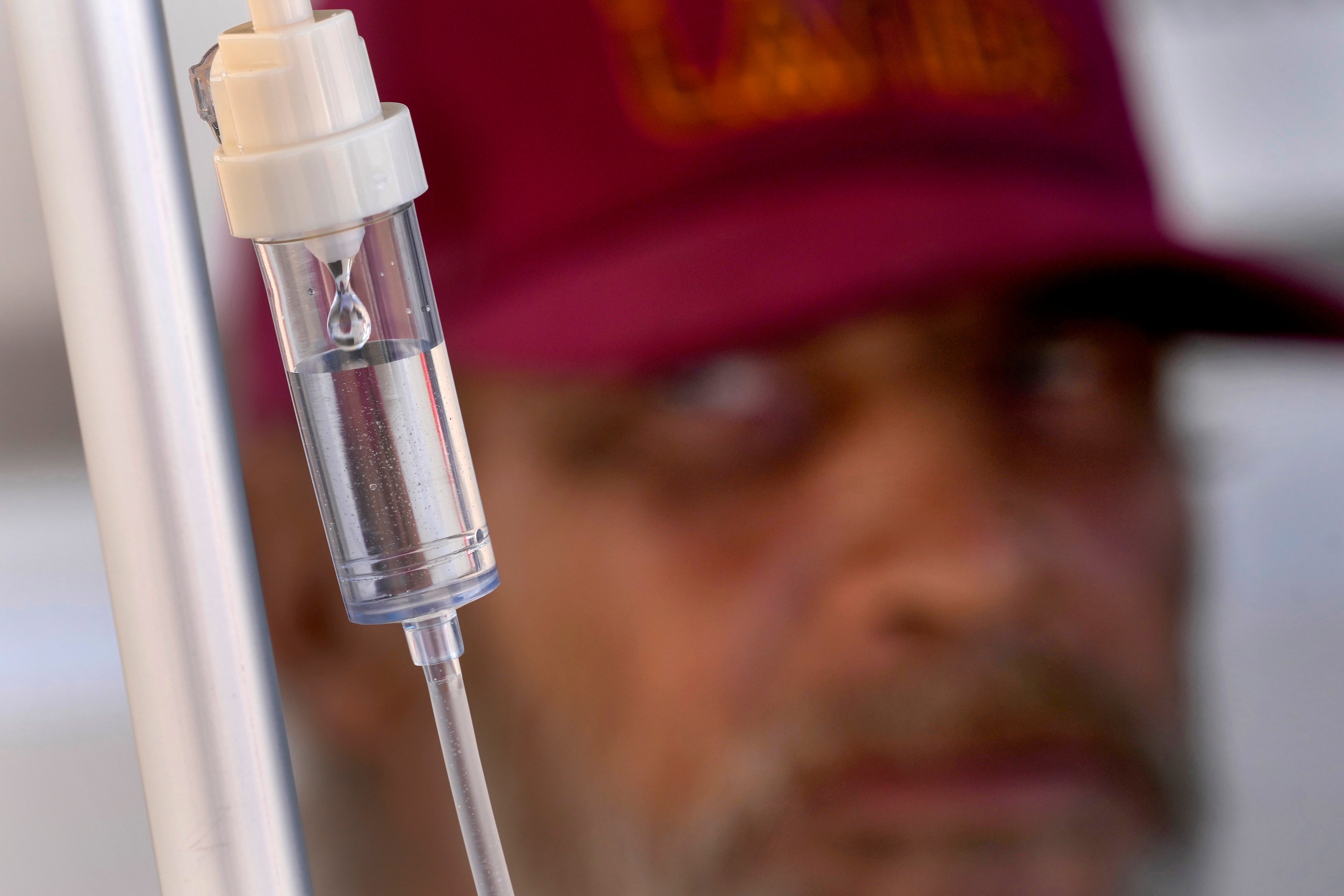 Alfred Handley watches an intravenous saline solution drip administered by the Circle The City medical team, Thursday, May 30, 2024 in Phoenix