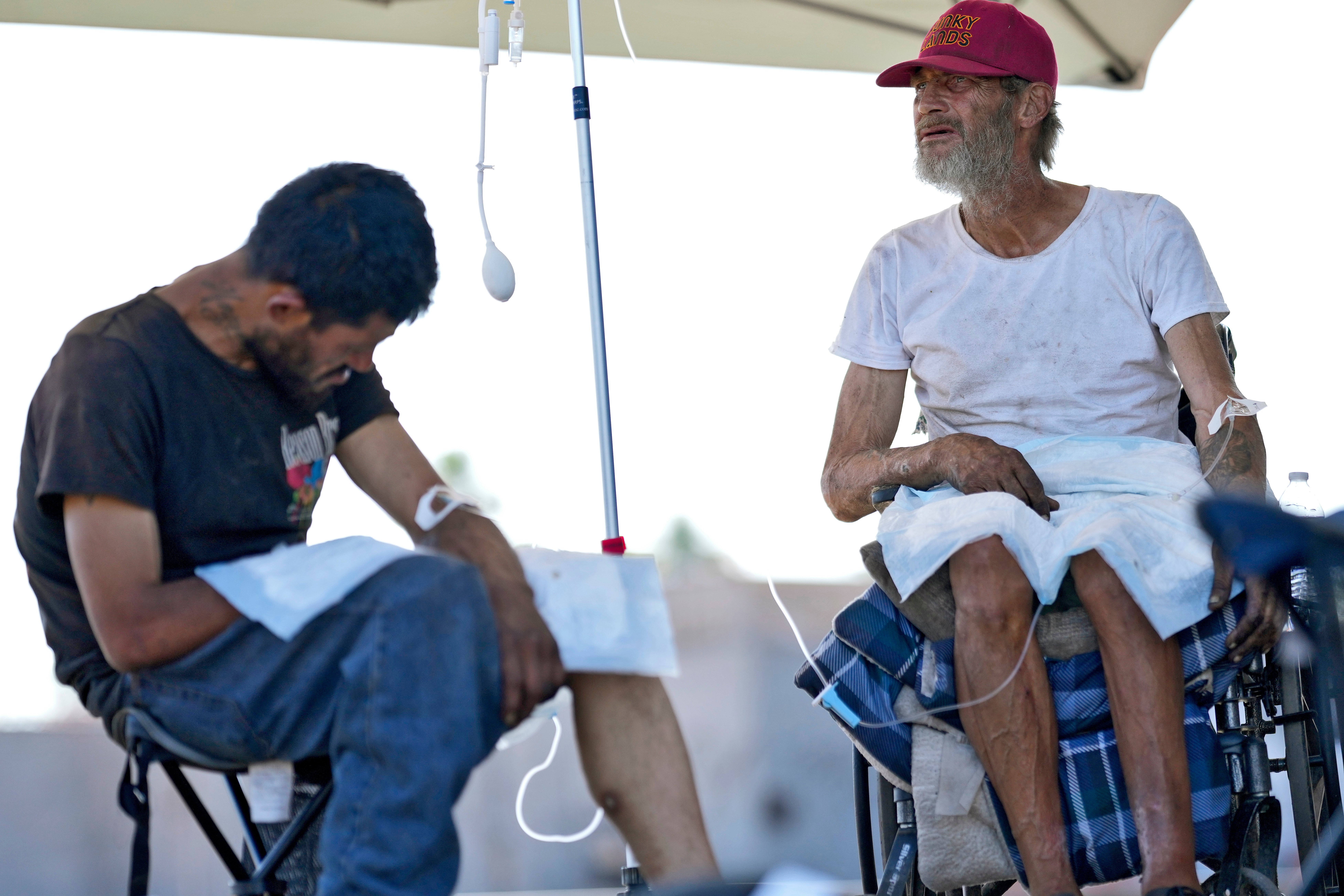 Phillip Enriquez, left, and Alfred Handley receive intravenous saline solution from a Circle The City mobile clinic, Thursday, May 30, 2024 in Phoenix