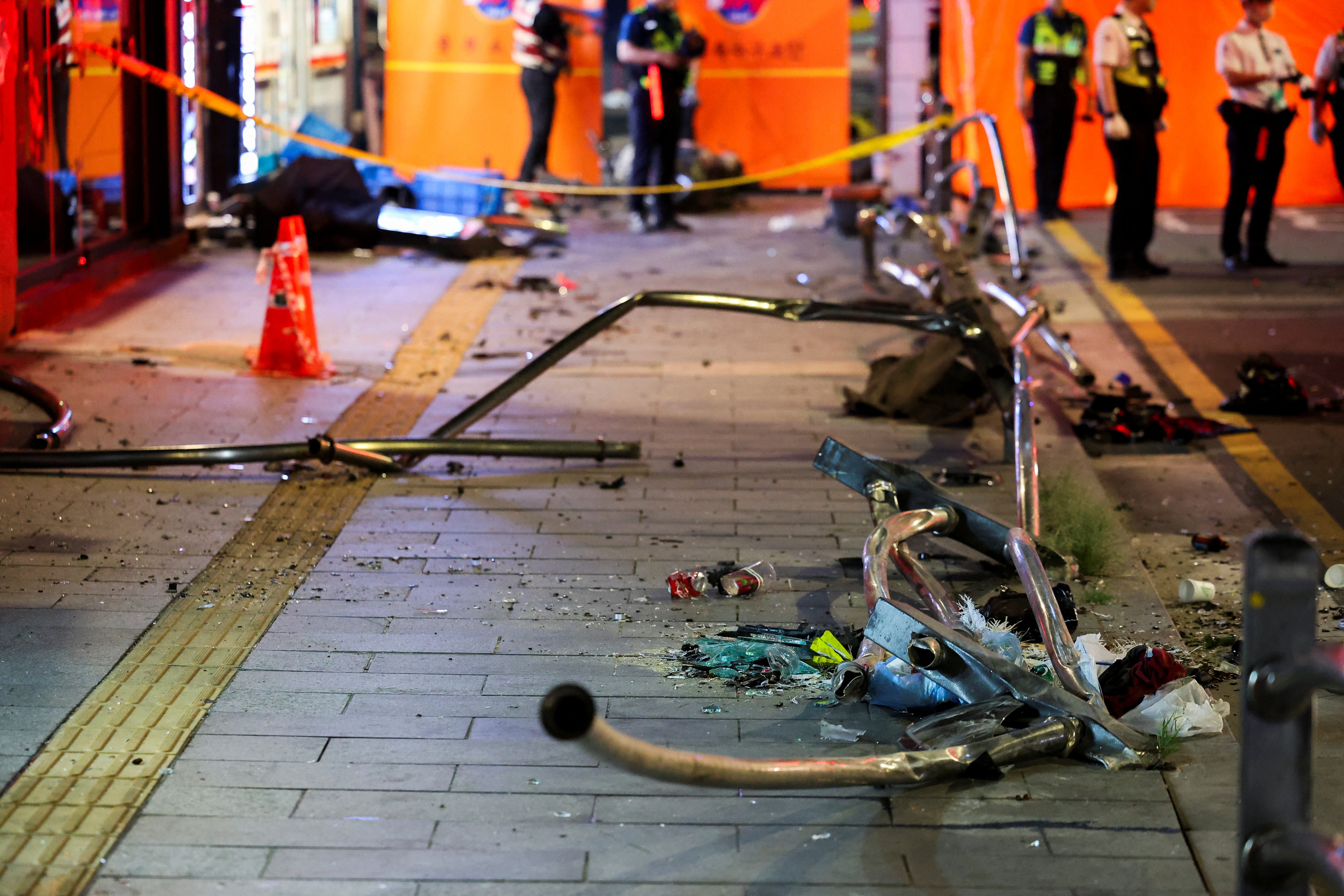 Broken glass and debris lie at the scene of car accident that resulted in several people killed and injured in central Seoul