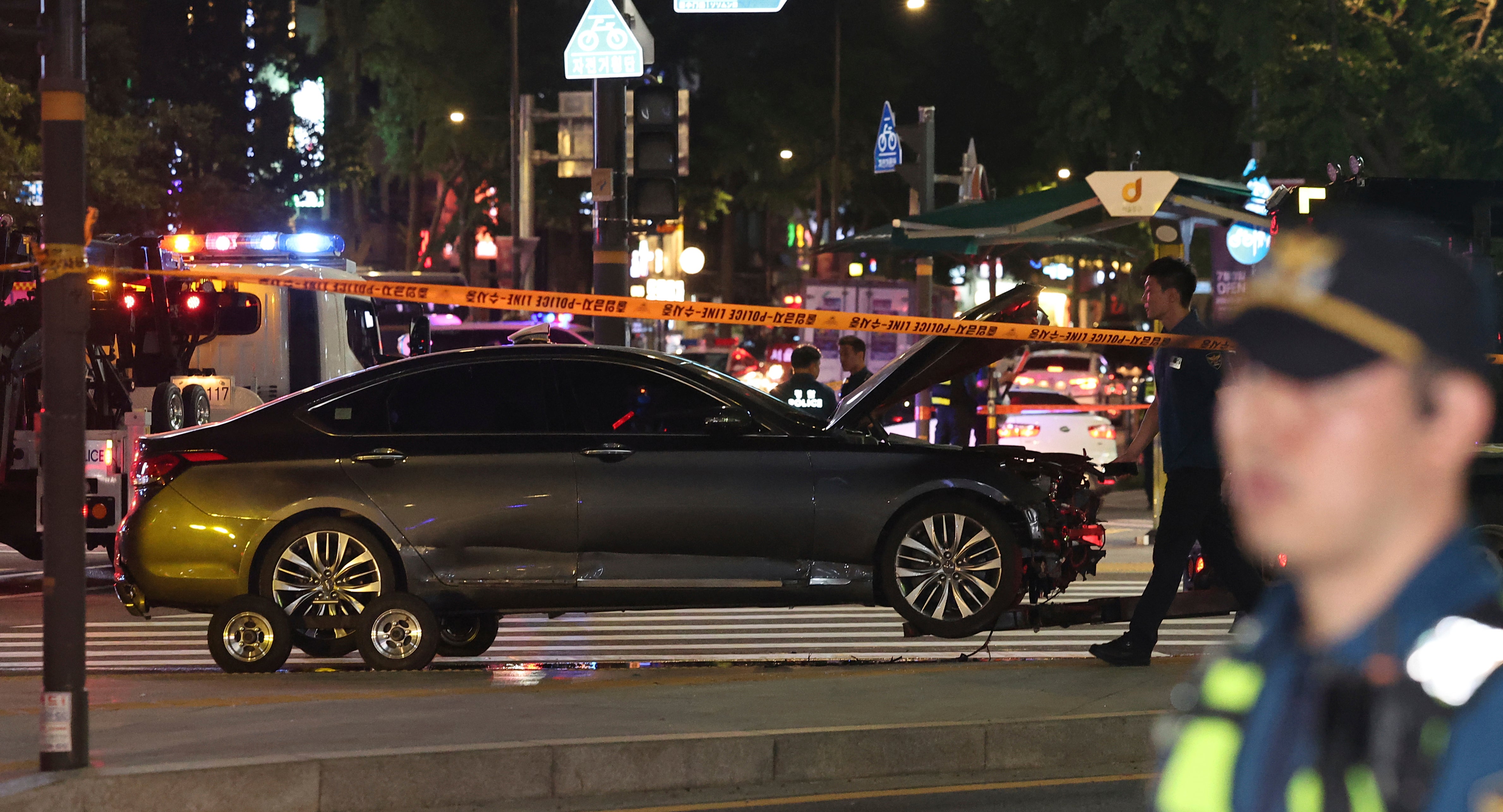 Police officers control a car accident scene near Seoul City Hall in downtown Seoul, South Korea, Monday
