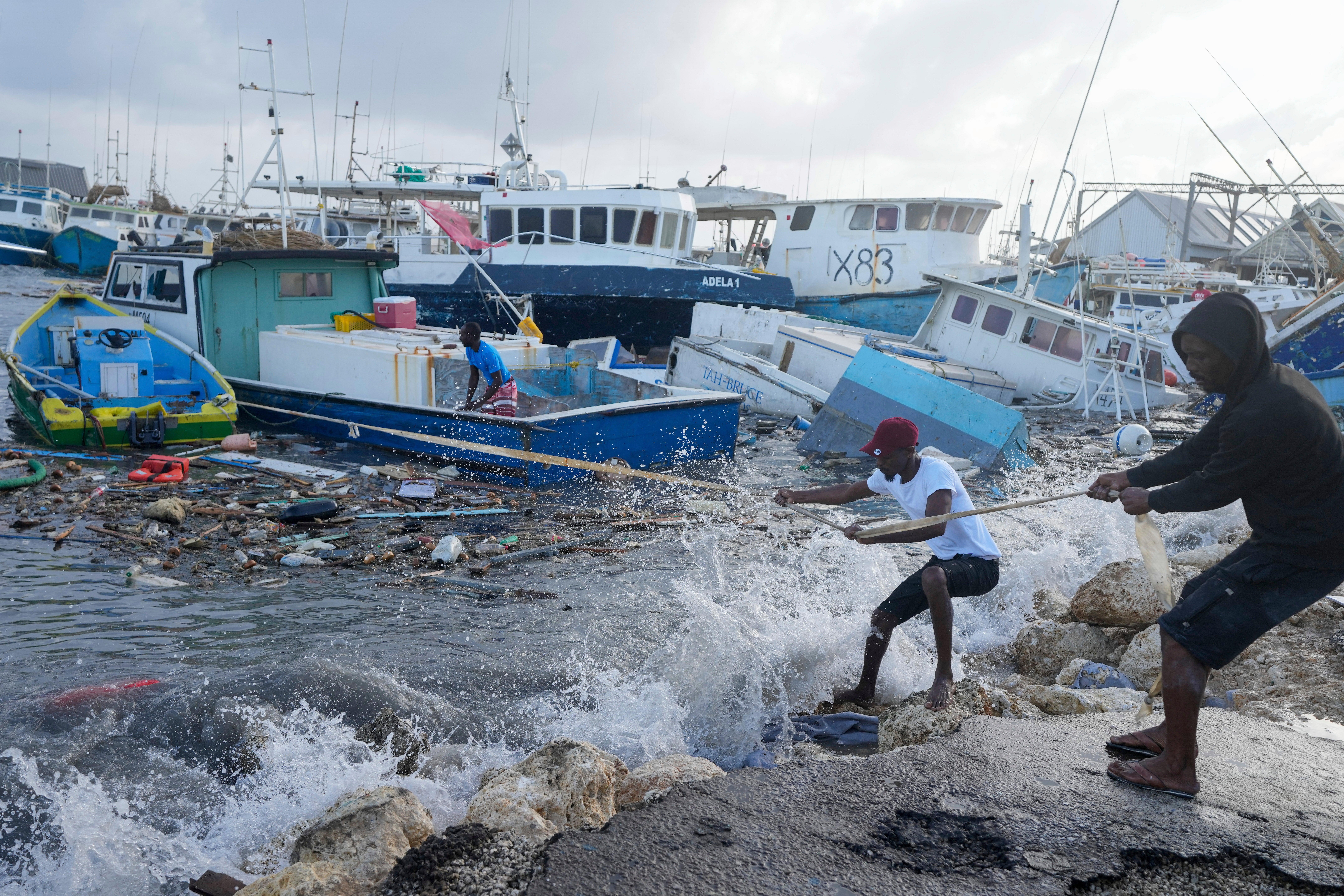 Fishermen try to pull a wrecked boat from the water after Hurricane Beryl struck Barbados on Monday.