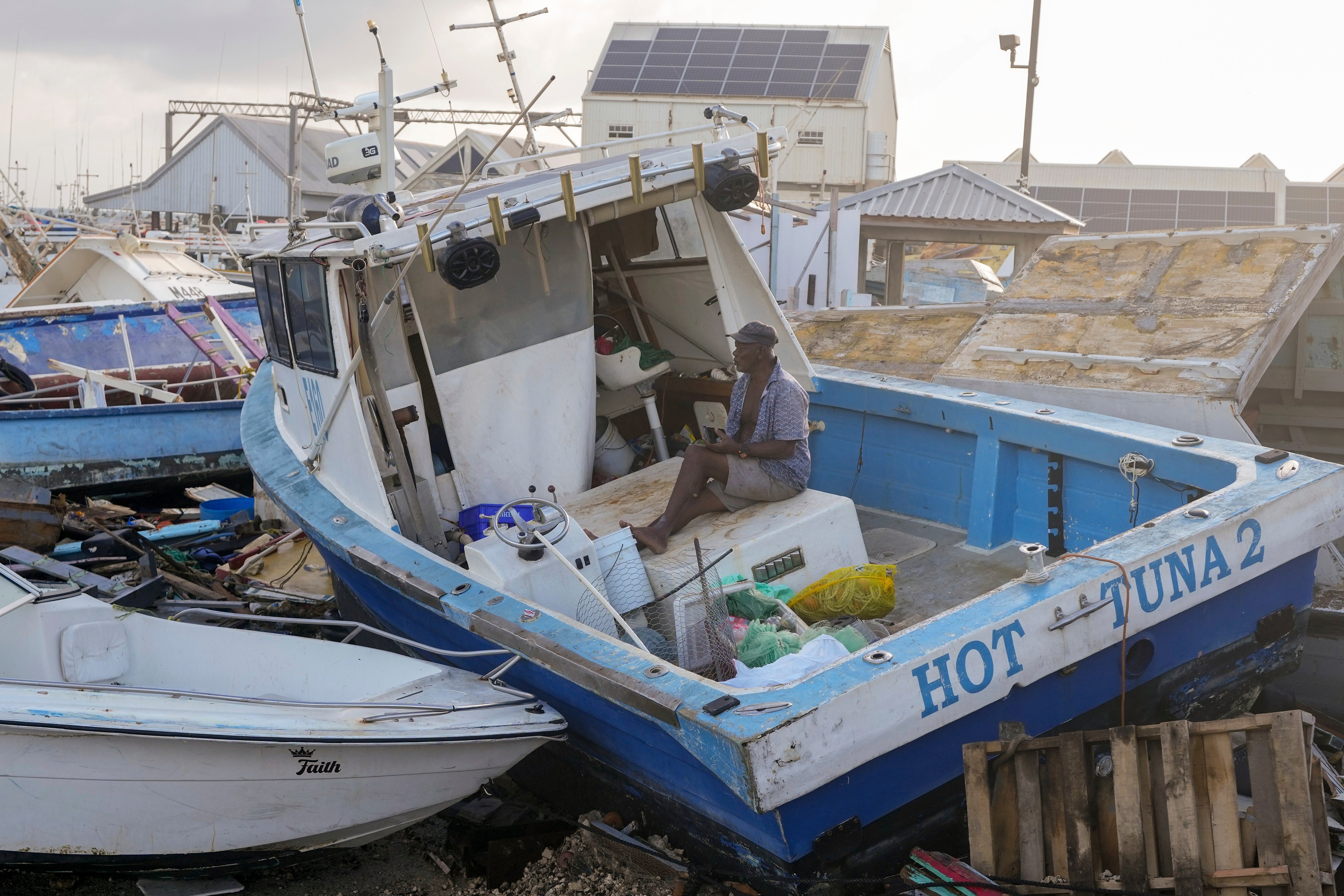 Fisherman Hamilton Cosmos looks at vessels damaged by Hurricane Beryl at the Bridgetown Fisheries in Barbados