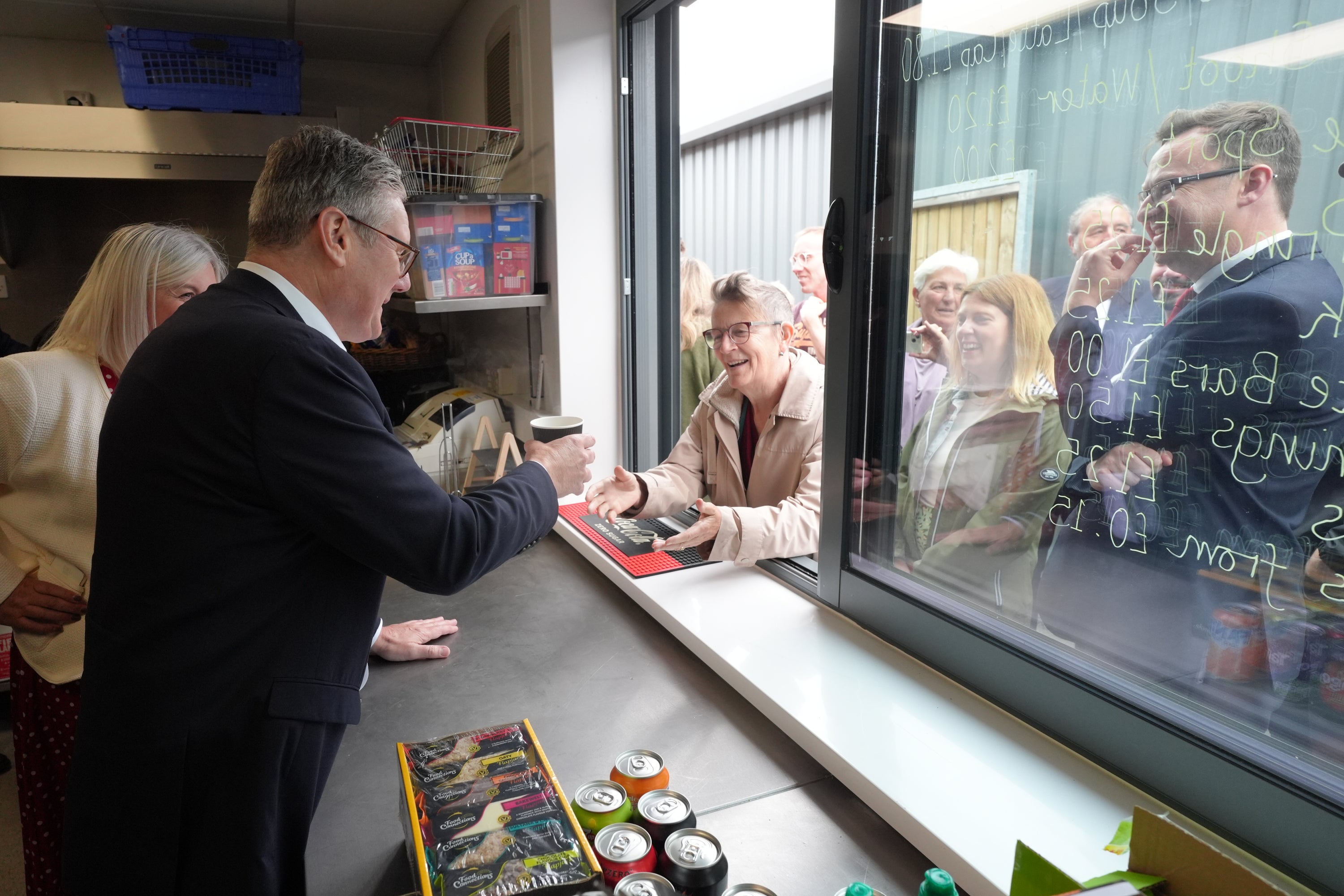 Sir Keir Starmer serves customers hot beverages during a visit to Hucknall Town FC in Nottinghamshire
