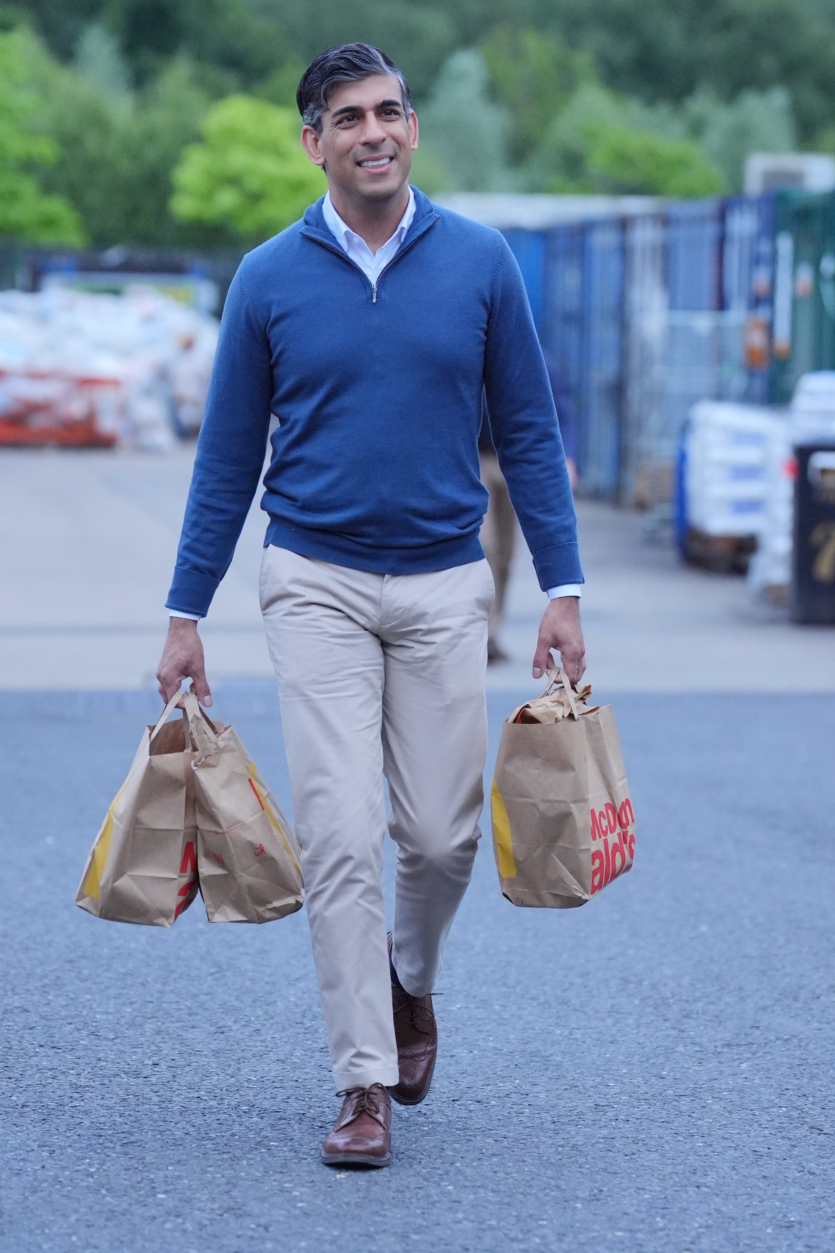 Rishi Sunak often pairs his blue knit with traditional taupe chinos and brown brogues (Jonathan Brady/PA)