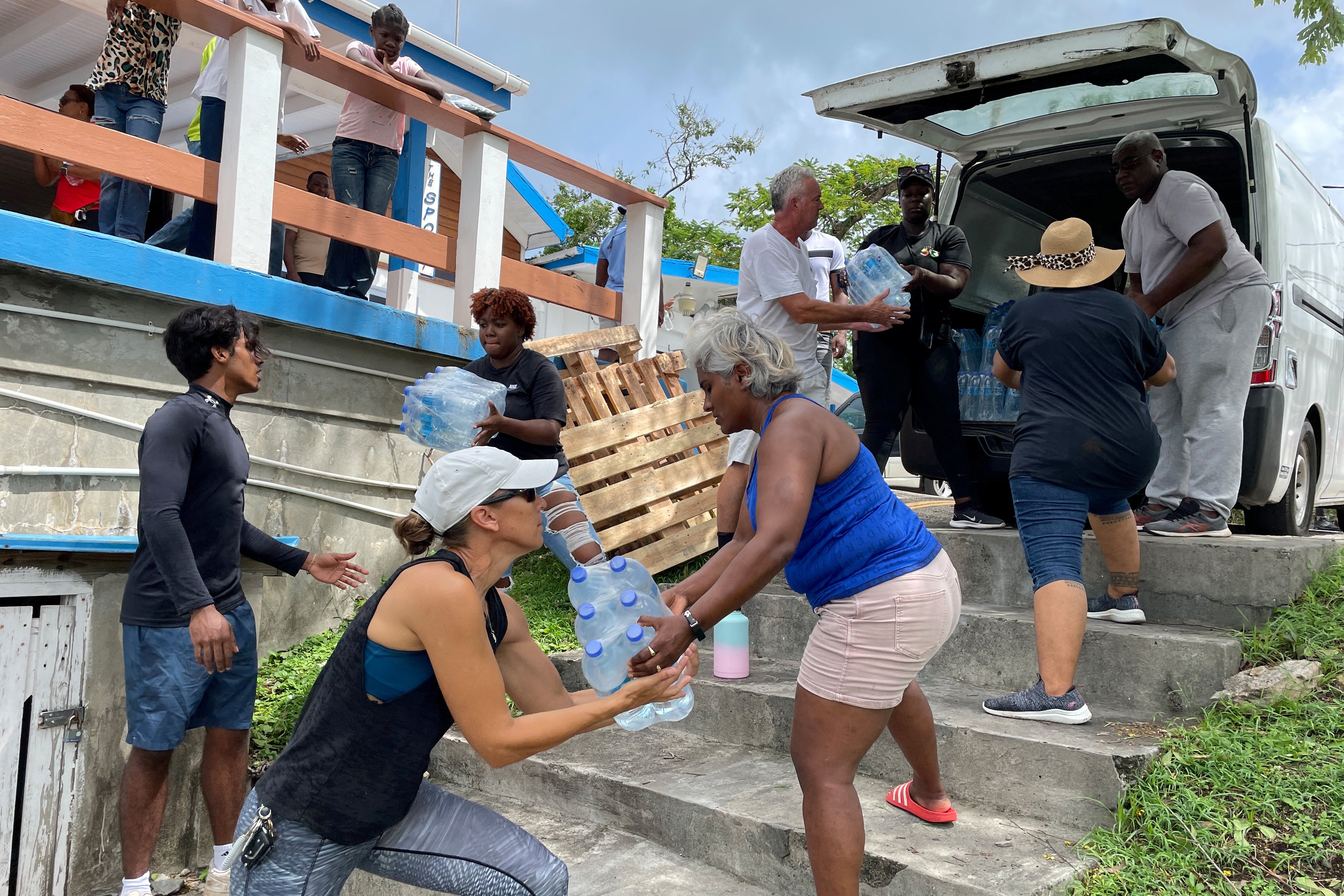 People load essential supplies for residents of Carriacou Island, which was ‘flattened’ in half an hour by Beryl on Monday