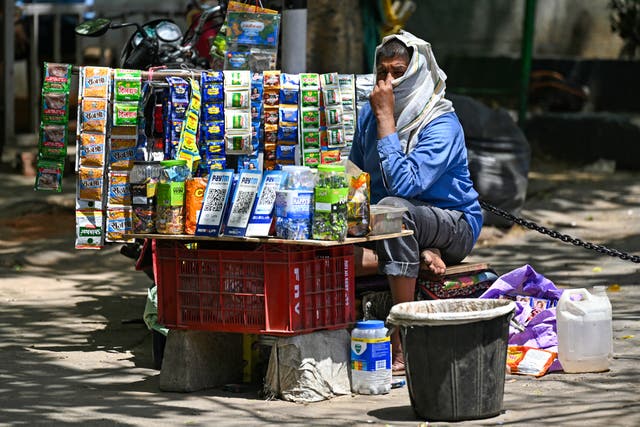 <p>A  vendor covers his face with a cotton cloth on a hot summer day in New Delhi</p>