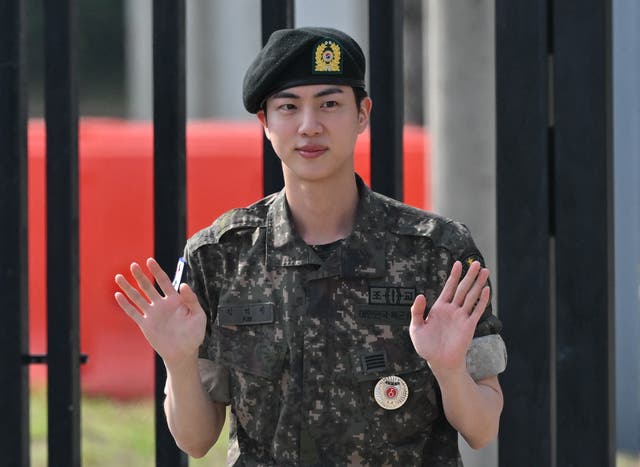 <p>Jin waves after being discharged from his mandatory military service on 12 June 2024</p>