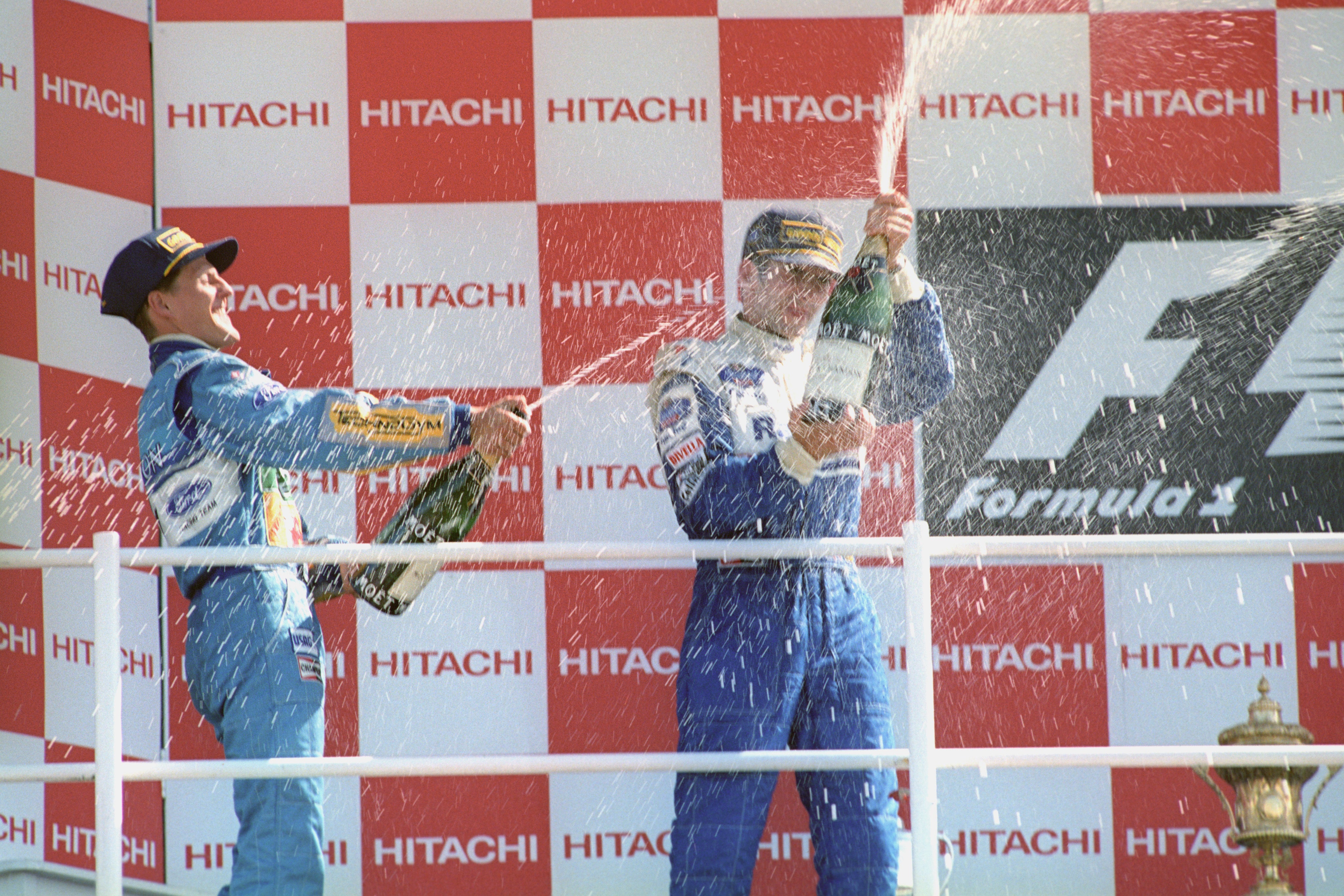 Michael Schumacher (right) sprayed Damon Hill with champagne before he was later disqualified from the race (PA Archive)