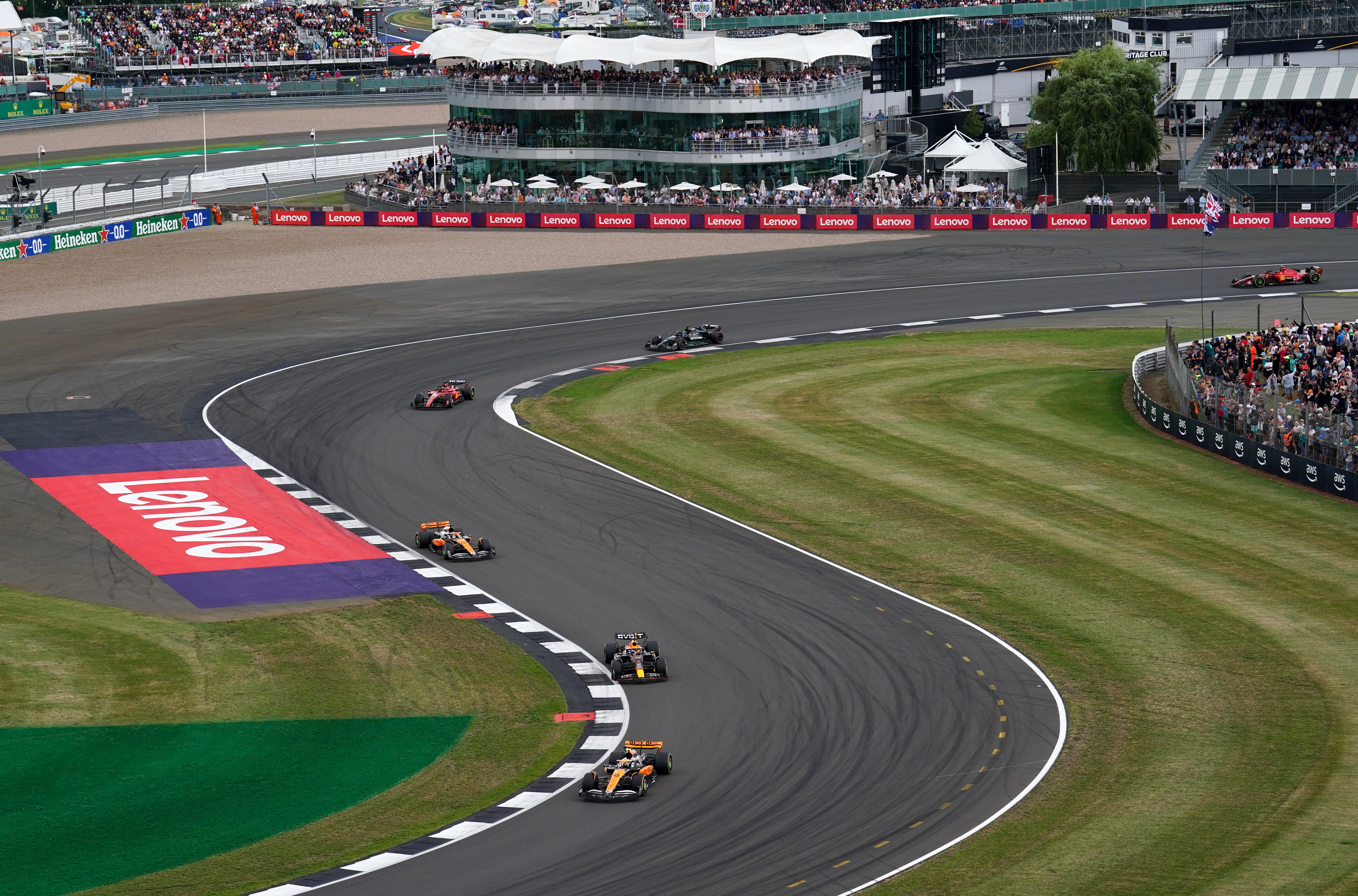 McLaren’s Lando Norris leads Red Bull’s Max Verstappen through Brooklands during the British Grand Prix (David Davies/PA)